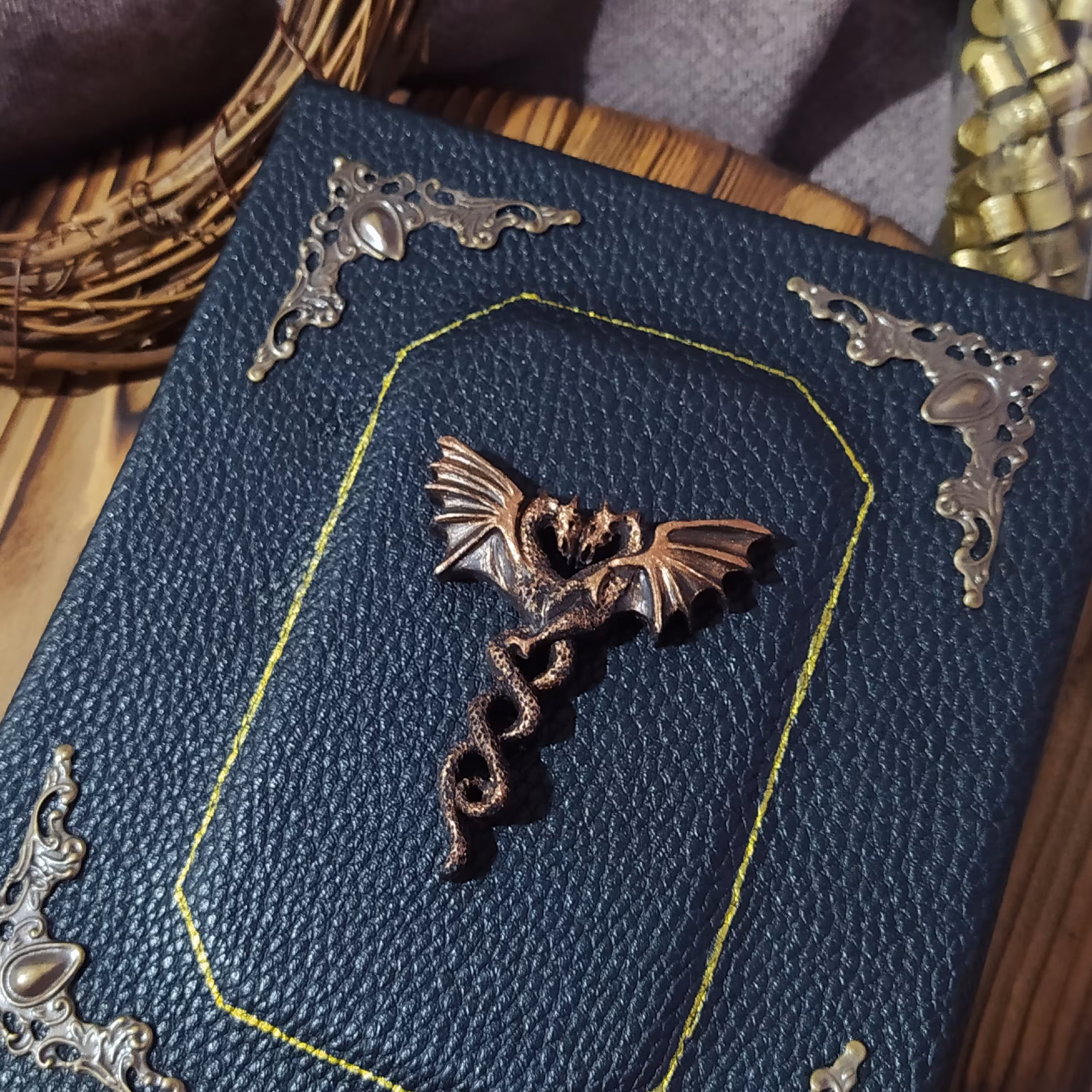 کلاسور جلد سخت چرمی 16.5 در 14 چرم مشکی  اکسسوری اژدها دست ساز  پتینه کاری مسی شده به همراه صد برگ کاغذ خط دار نخودی 