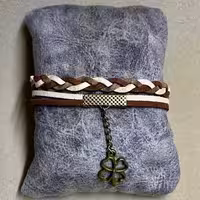 دستبند تریشه چرمی مدل بافت دورنگ قهوه ایی و کرم همراه با زنجیر و خرج کار برنزی 