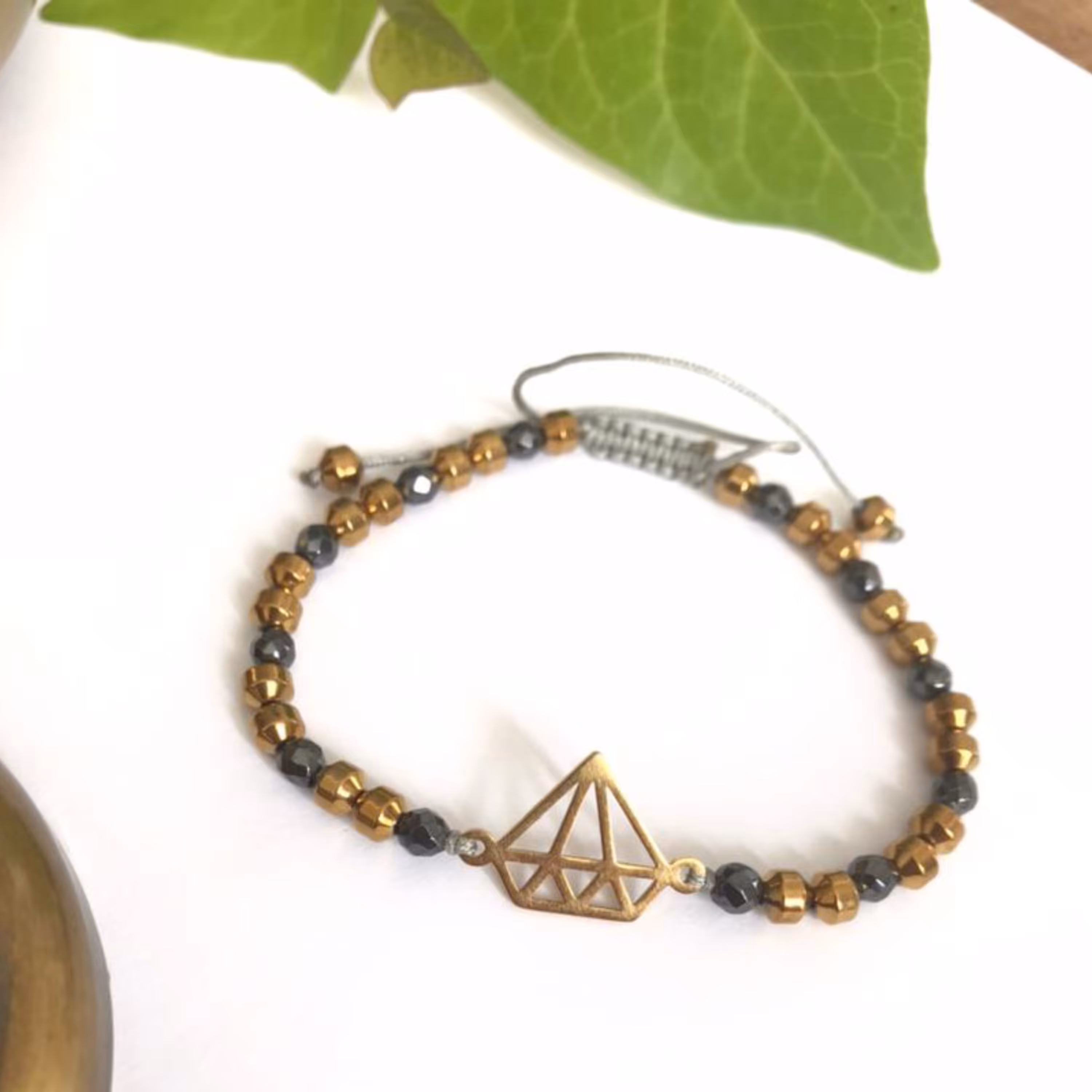 دستبند مدل جم تلفیقی از سنگ های هماتیت تراش زنبوری و واشری همچنین پلاک استیل الماس