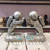مجسمه دکوری پلی استر  نگهدارنده کتاب طرح فضانورد رنگ نقره ای سایز  20 سانتی متر