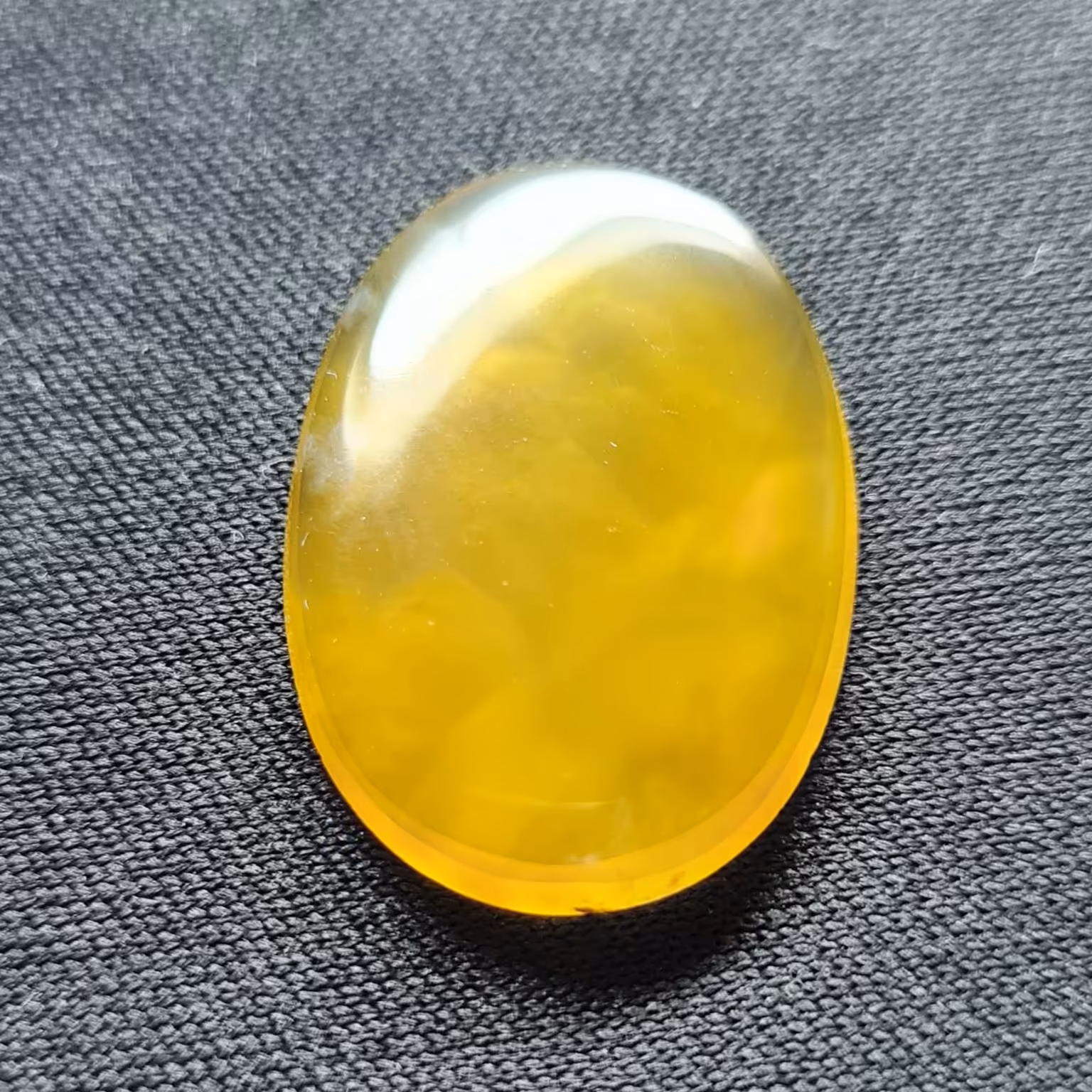 نگین عقیق زرد. مشخصات. طول 2.5 سانتی متر. عرض 1.8 سانتی متر. ارتفاع 0.3 سانتی متر.