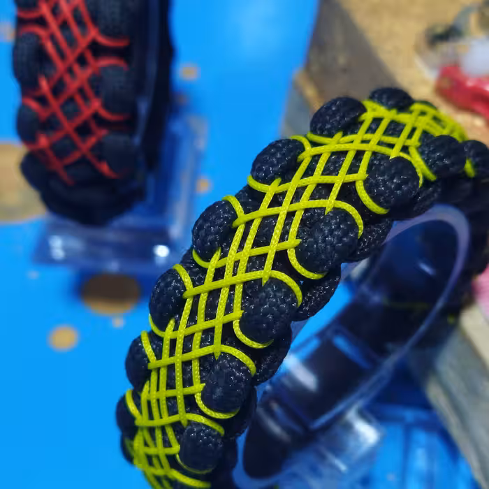 دستبند پاراکورد و نخ زرگری  سگک دار رنگبندی پاراکورد مشکی و نخ زرد و قرمز