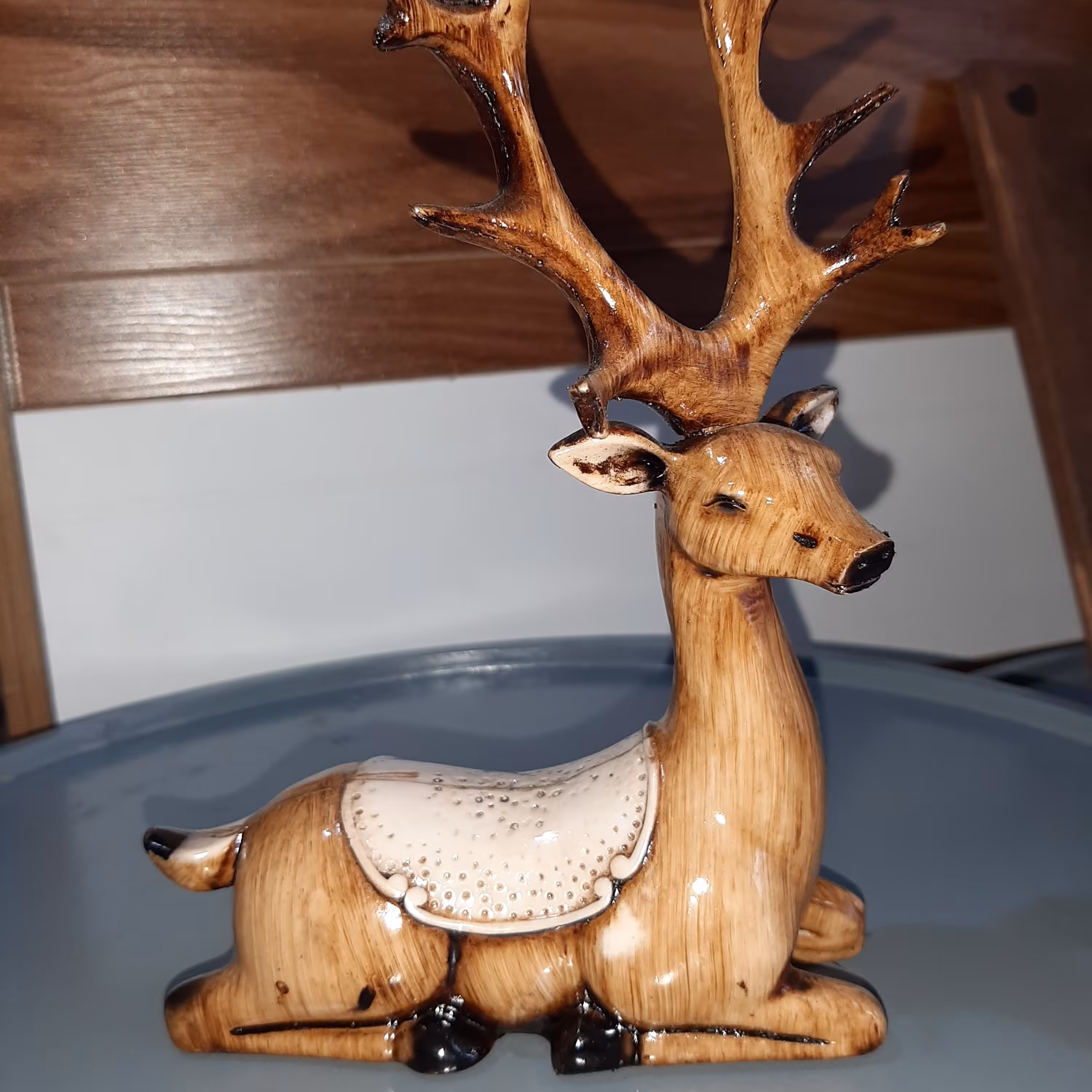 مجسمه گوزن طرح زین دارنشسته دررنگ قهوه ای باشاخکهای مشکی