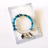 دستبند بنگل فنری طلایی آویزدار ، کار شده با سنگ آپاتیت آبی Apatite