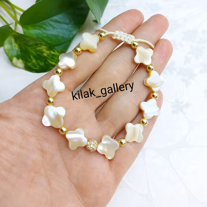 دستبند صدفی کاراملی اصل و حدید طلایی و گوی سوارسکی طلایی  مدل نوشا