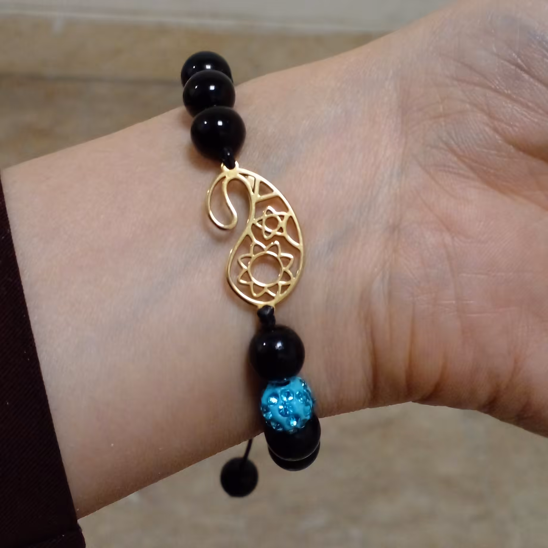 دستبند سنگی انیکس مشکی براق با پلاک استیل بته جقه رنگ طلا