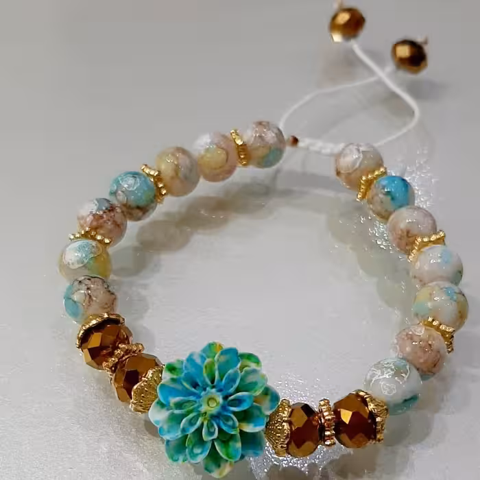 دستبند طرح شکوفه سبز فیروزه ای و مروارید سنگی آبرنگی و کریستال طلایی