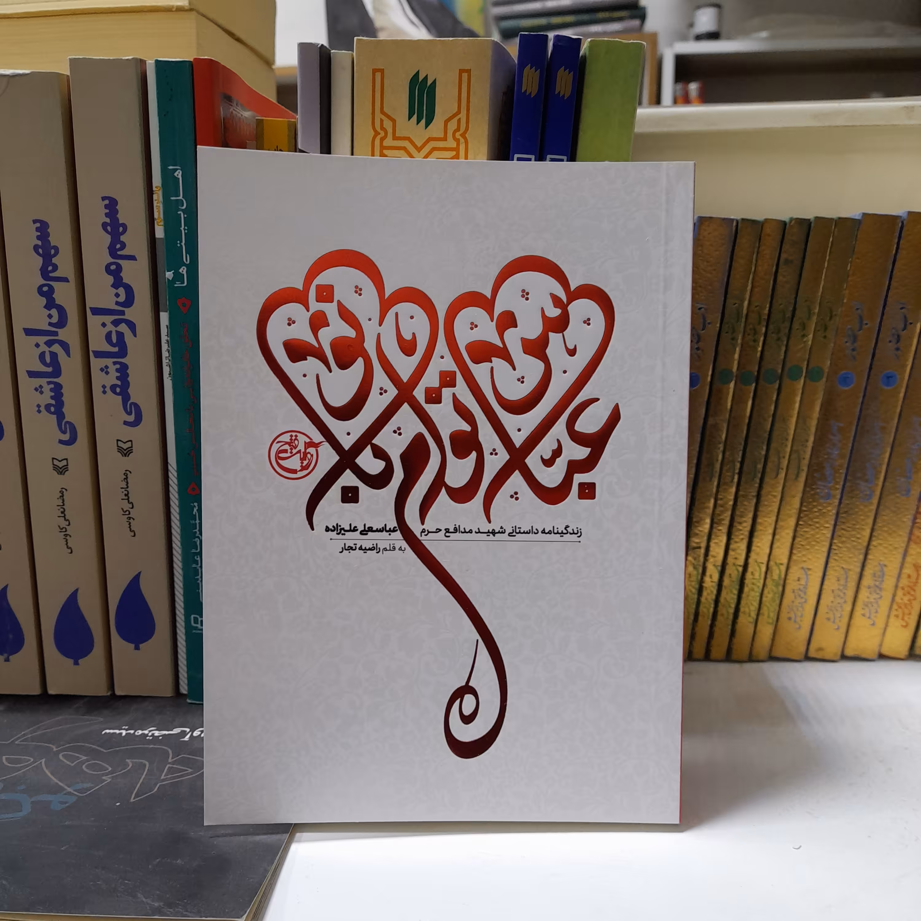 کتاب عباس توام بانو،زندگینامه داستانی شهید مدافع حرم عباسعلی علیزاده،به قلم راضیه تجار،انتشارات روایت فتح 