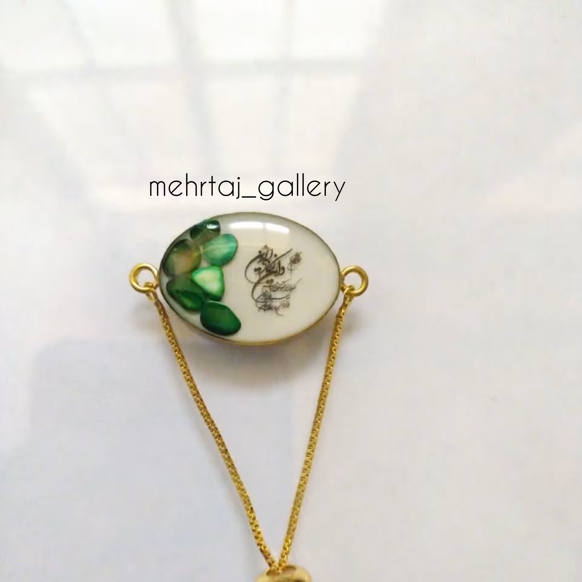 دستبند رزینی طرح سنگ سبز با قاب بیضی برنجی طلایی