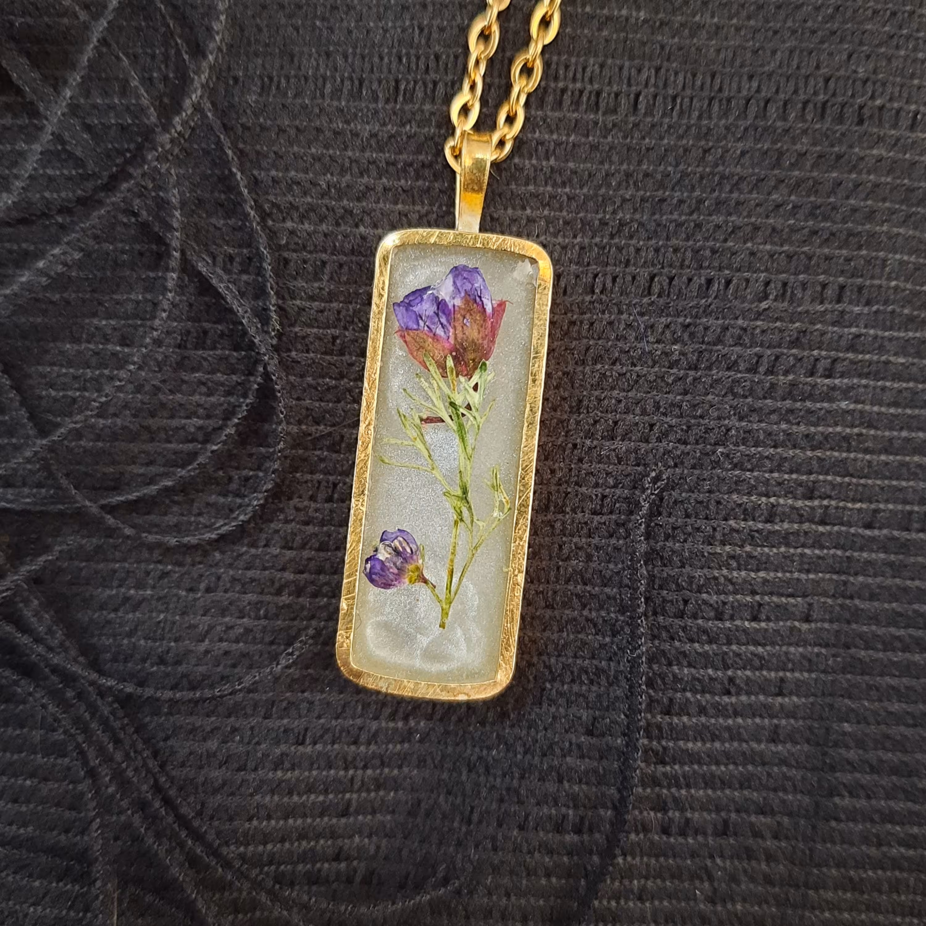 گردنبند رزینی مستطیلی با گل طبیعی بنفش با فریم طلایی