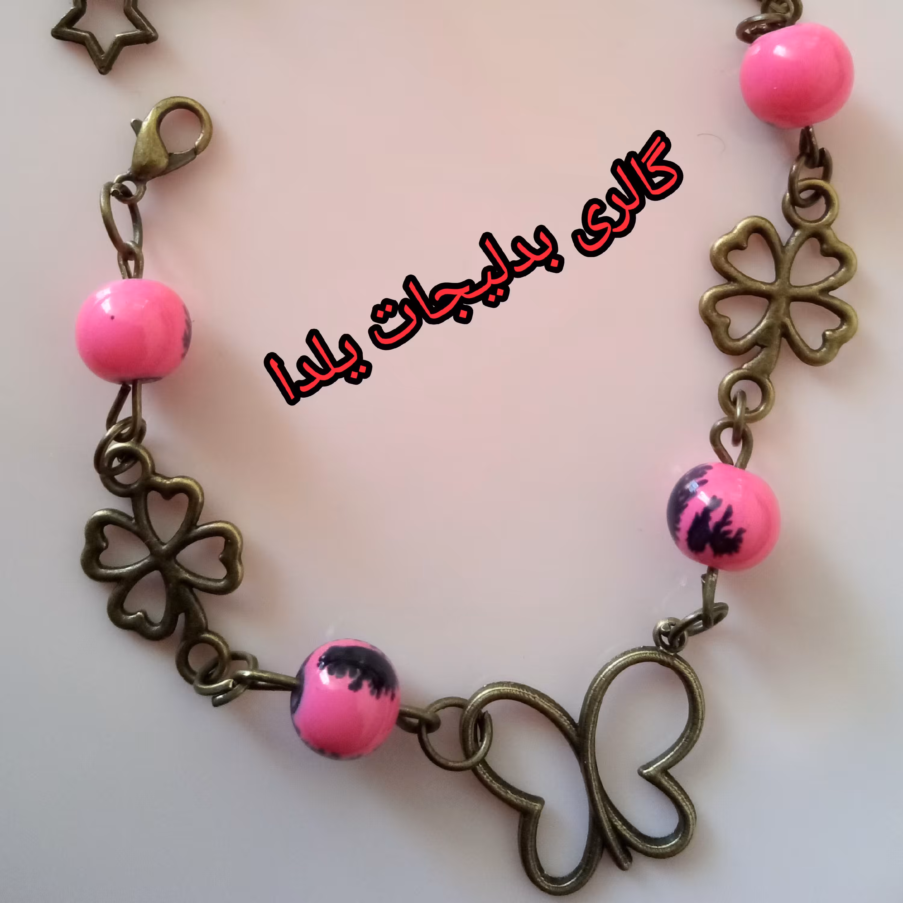 بدلیجات دستبند پروانه باخرج کار برنز طرح پروانه وخرج کار گل برنزی وتزئین شده با مهره های سنگی آبرنگی صورتی و مشکی ابرنگی