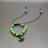 دستبند مدل آسانسوری با مهره های سبز سفری رنگ و خرج کار برنزی طرح فروهر 