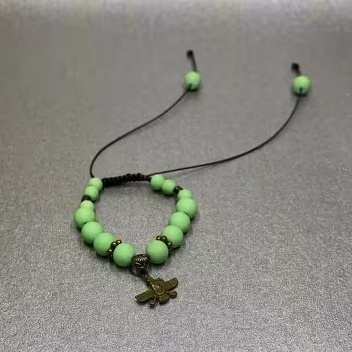 دستبند مدل آسانسوری با مهره های سبز سفری رنگ و خرج کار برنزی طرح فروهر 