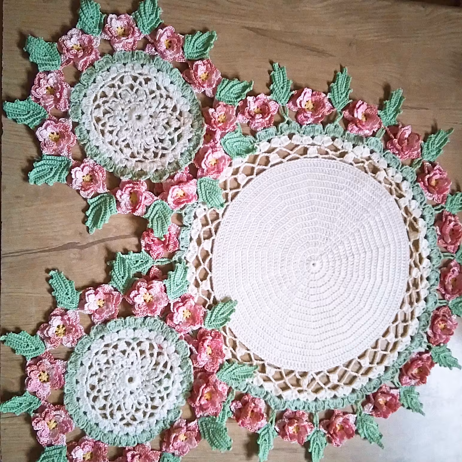 رومیزی گرد قلاببافی گل برجسته رنگ سفید شیری با گلهای ابریشم صورتی اسپرت مناسب میز خاطره