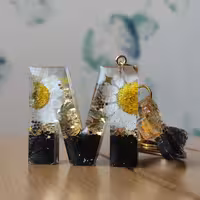 سرکلیدی گل بابونه طرح حرف M و اکلیل های براق