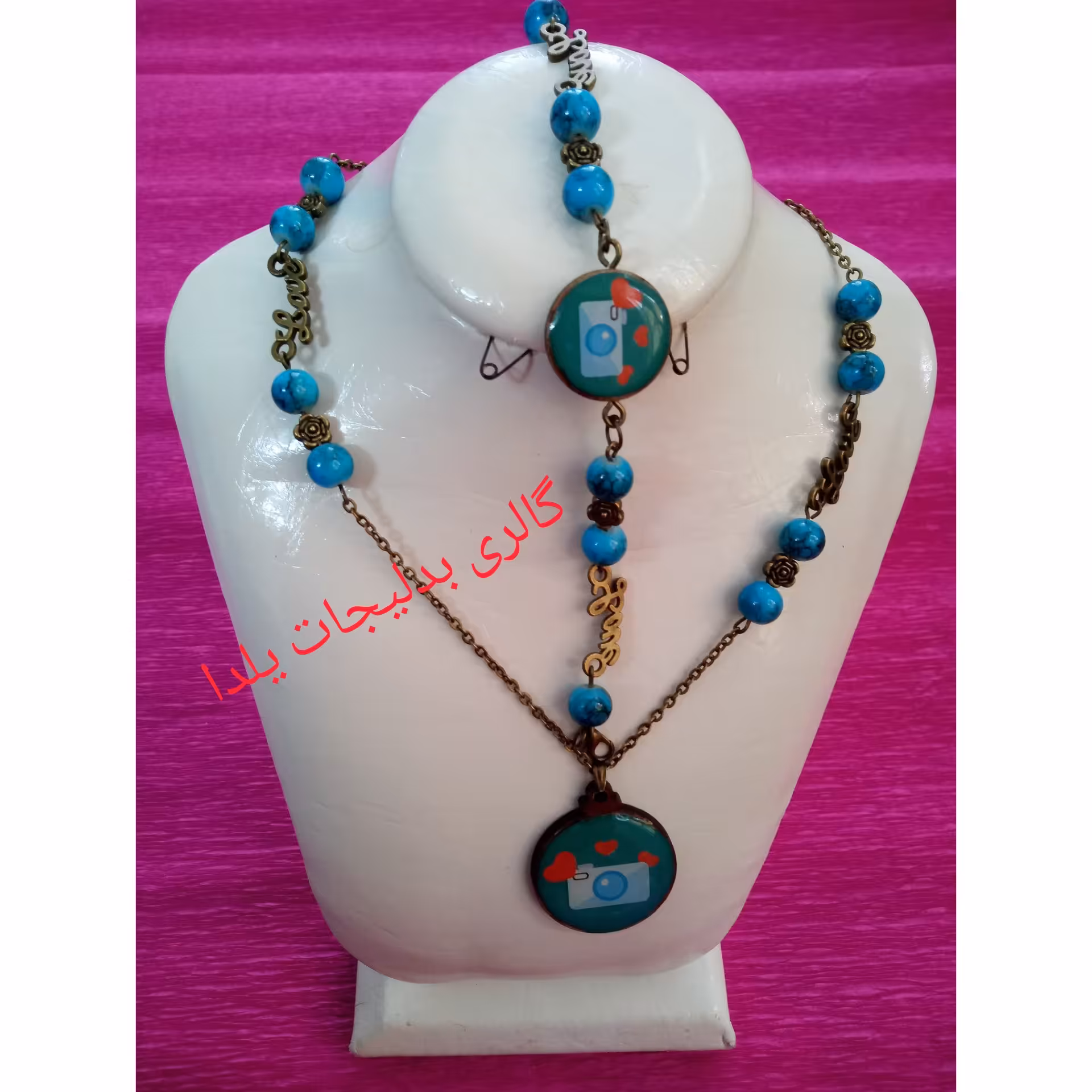 ست دستبند وگردنبند رزینی با طرح دوربین عکاسی وتزئین شده با مهره های سنگی آبی فیروزه ای وخرج کار لاو