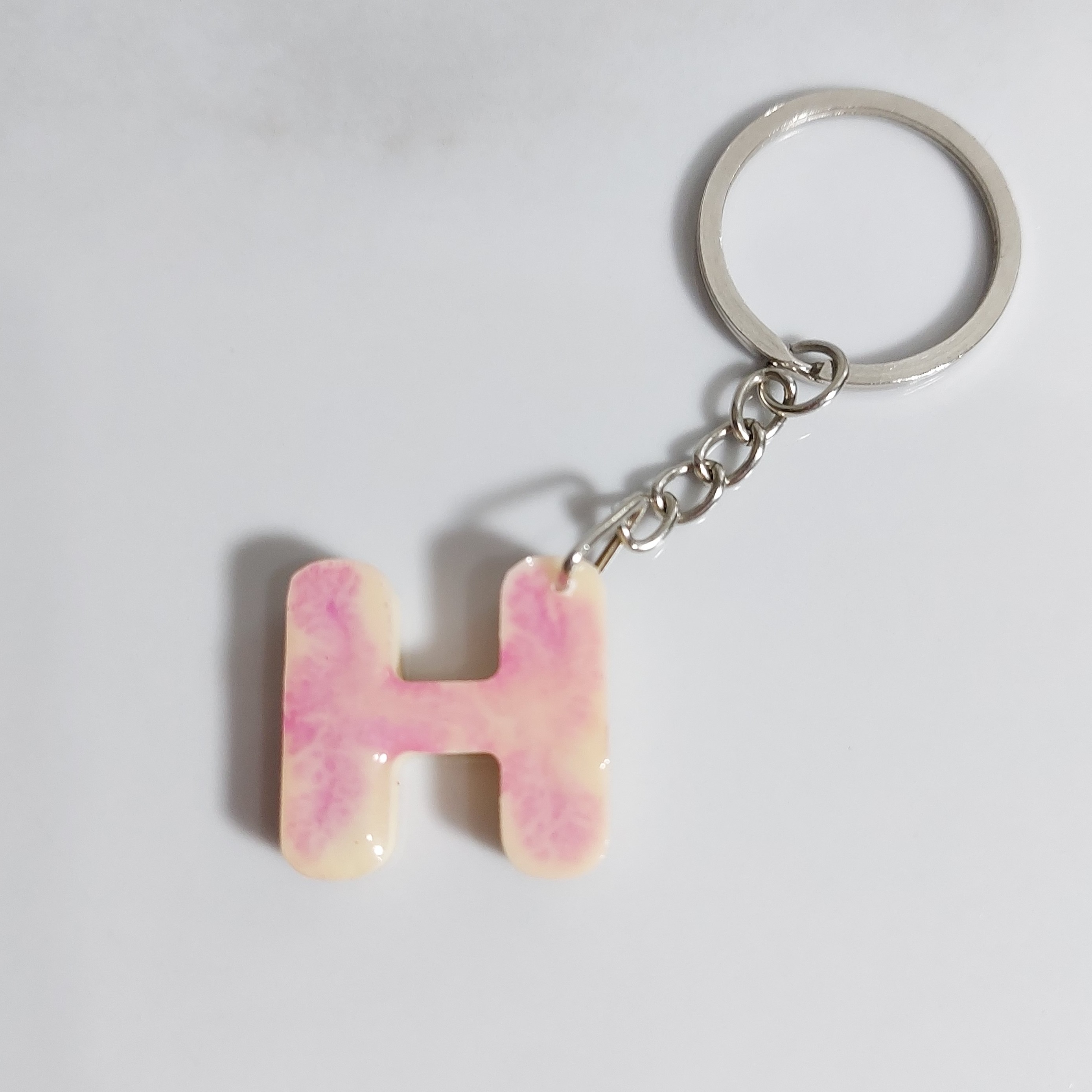 دسته کلید رزینی دوطرفه حرف H دورنگ کرمی بنفش