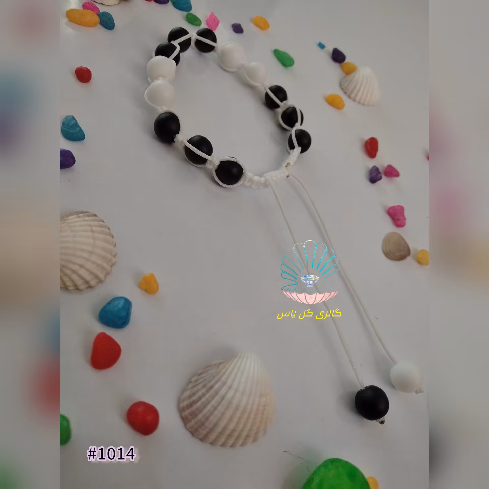 دستبند گره کشویی با مهره اونیکس سفید و مشکی و دور بافت با نخ سفید 