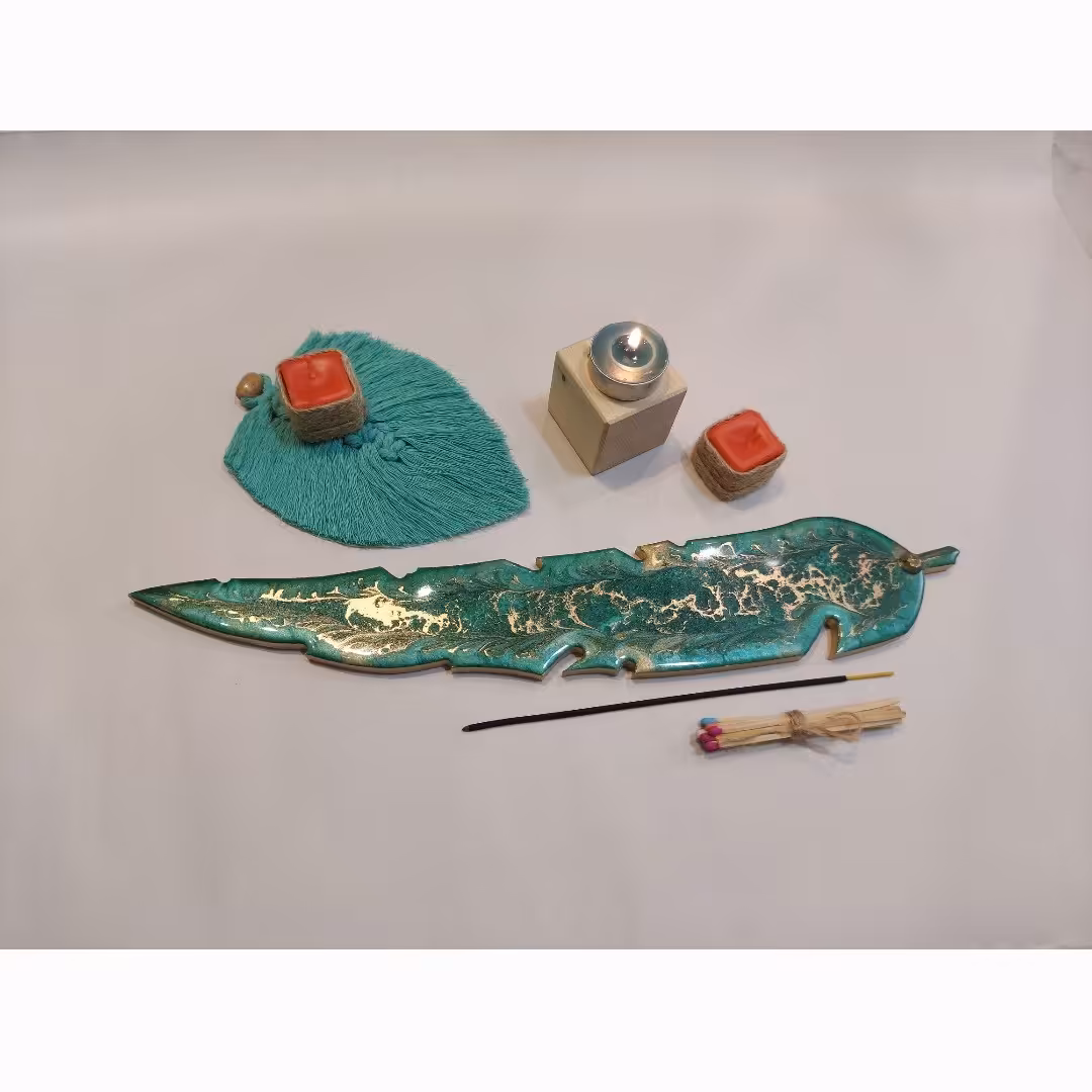  جاعودی برگ رزینی و یک پر مکرومه و دو عدد شمع قرمز کوچک و یک دسته کبریت شومینه