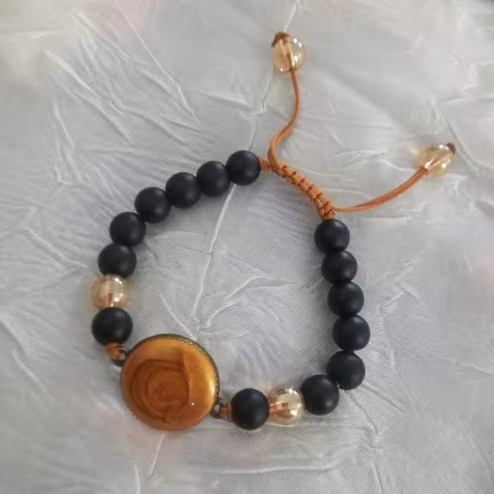 دستبند اونیکس مشکی با پلاک رزینی و مهره های شامپاین