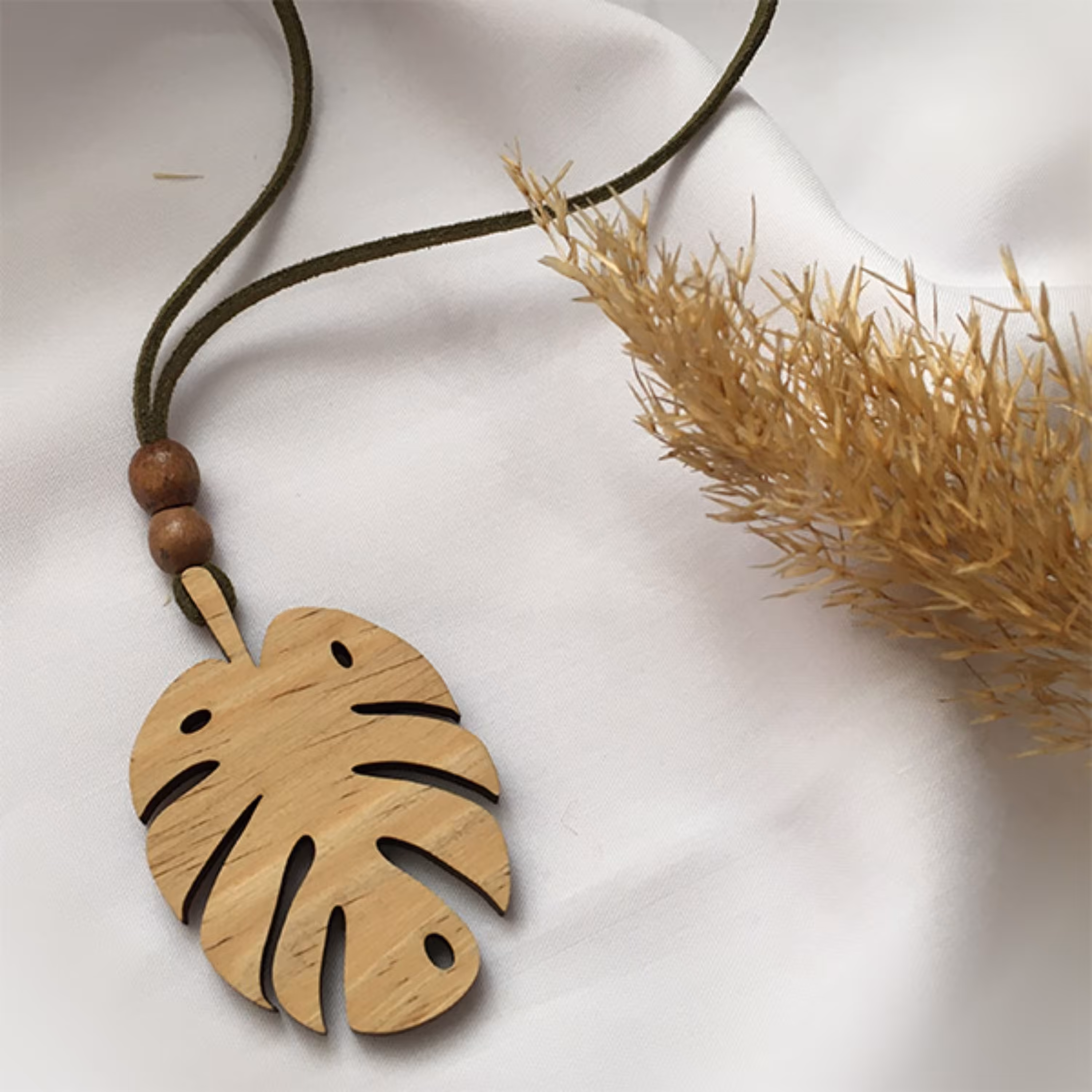 گردنبند چوبی مدل برگ انجیری ابعاد پلاک 5 در 3 سانتی متر با بند چرمی مشکی