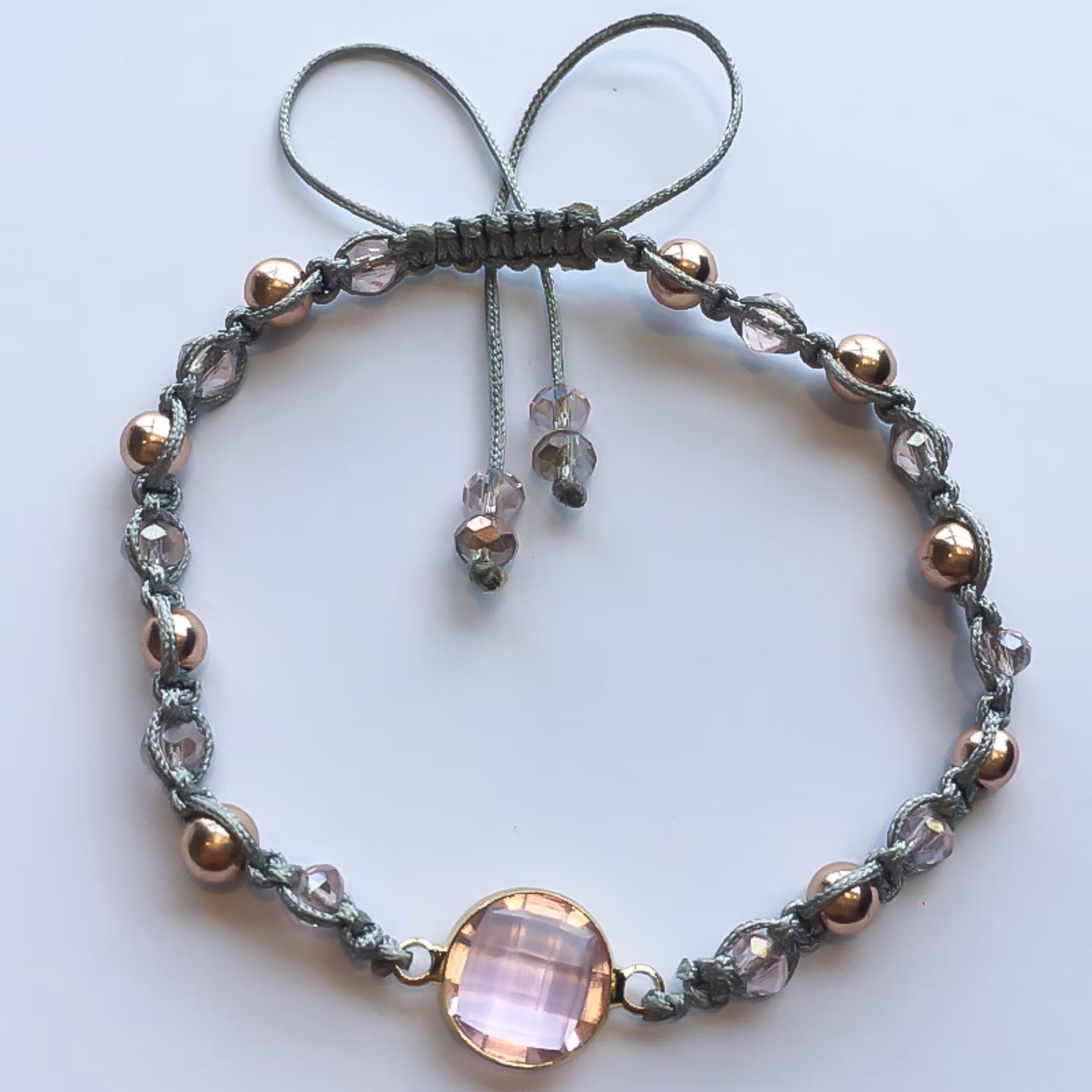 دستبند مدل فخریه  سنگ های هماتیت و کریستال صورتی روشن و همچنین بافت منحصر به فرد بین مهره ها