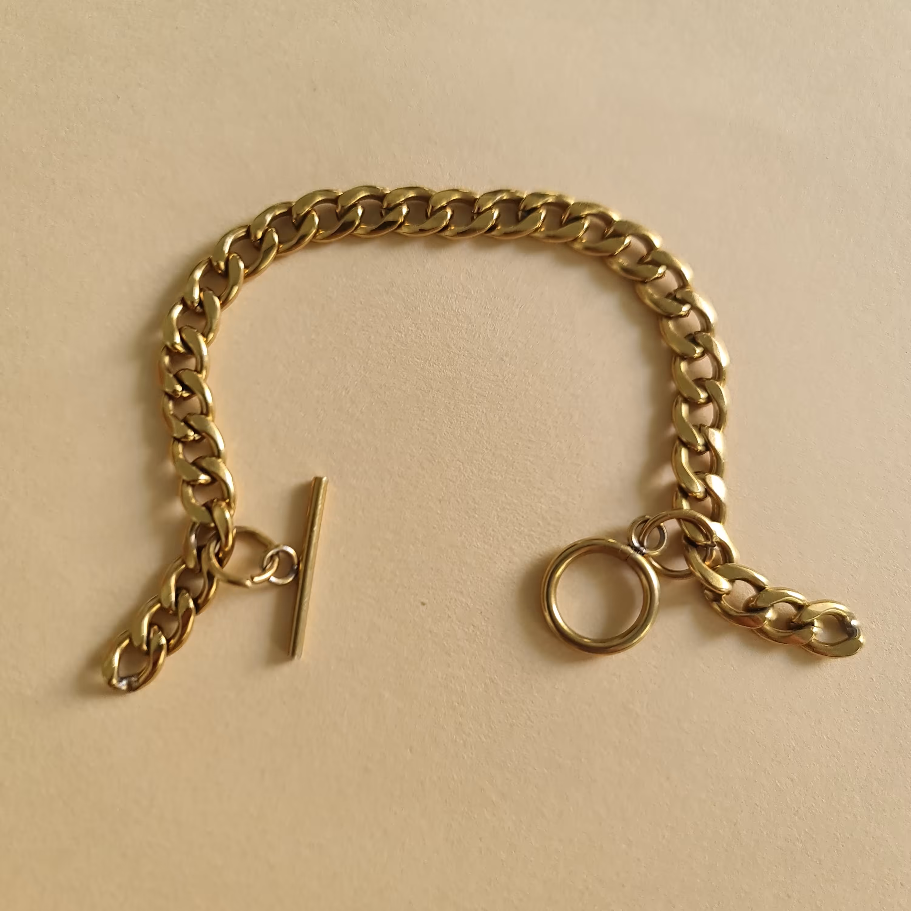 دستبند کارتیر طلایی با قفل تی طرح اویز دار