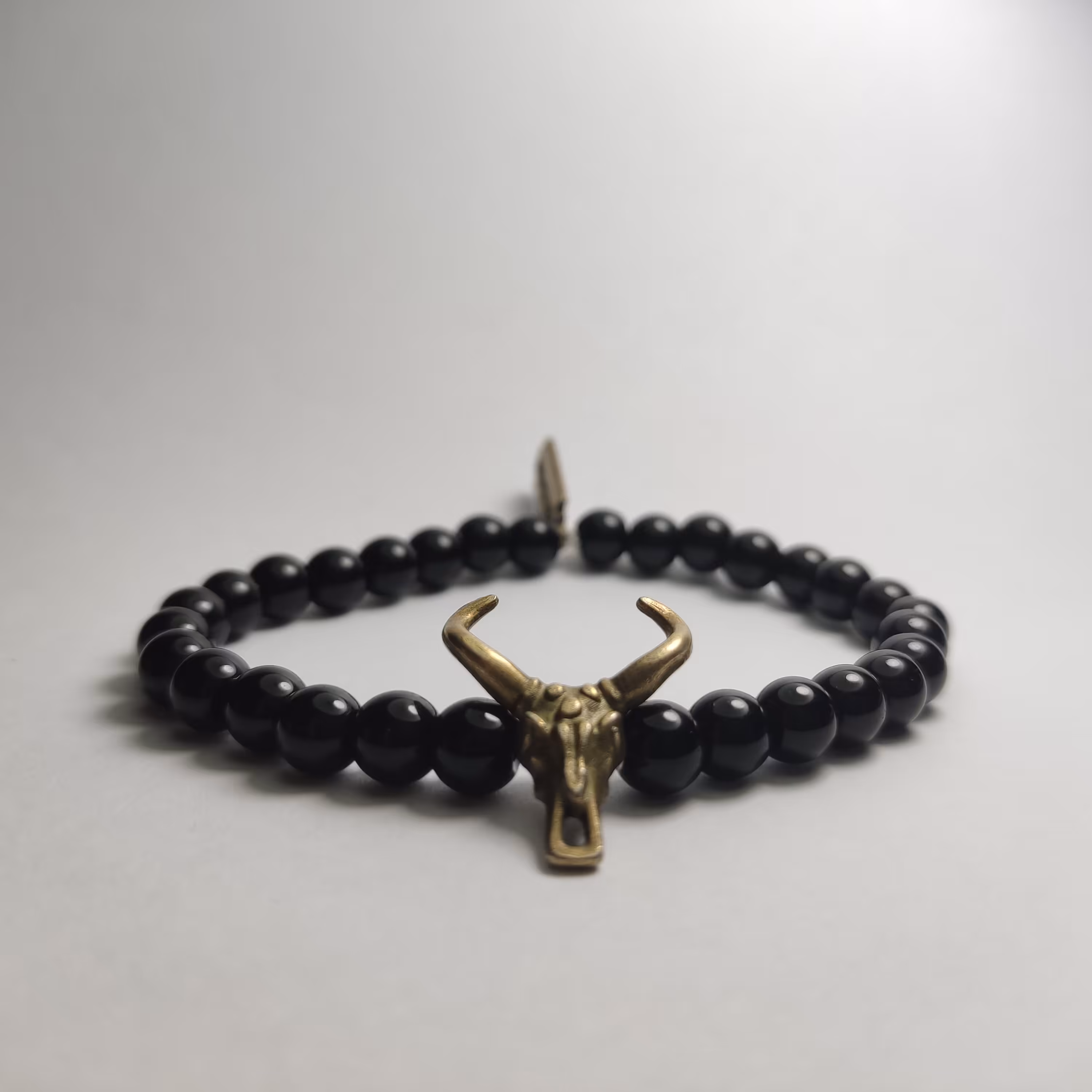 دستبند مشکی براق طرح(گوزن شیطان)با پلاک آویزان مدل تیغ