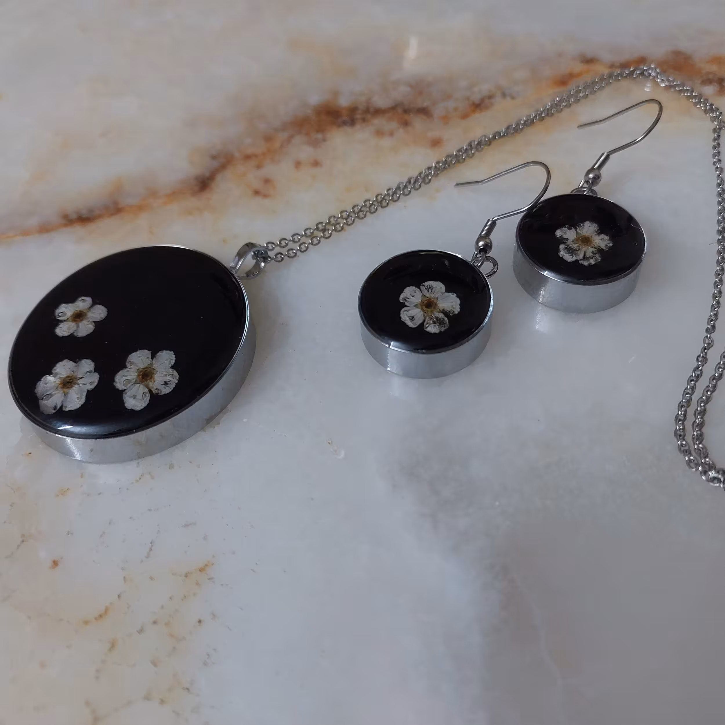 نیم ست زمینه سیاه با طرح زمینه گل جنس استیل  و روکش رزینی  با زنجیر وزن 40گرم