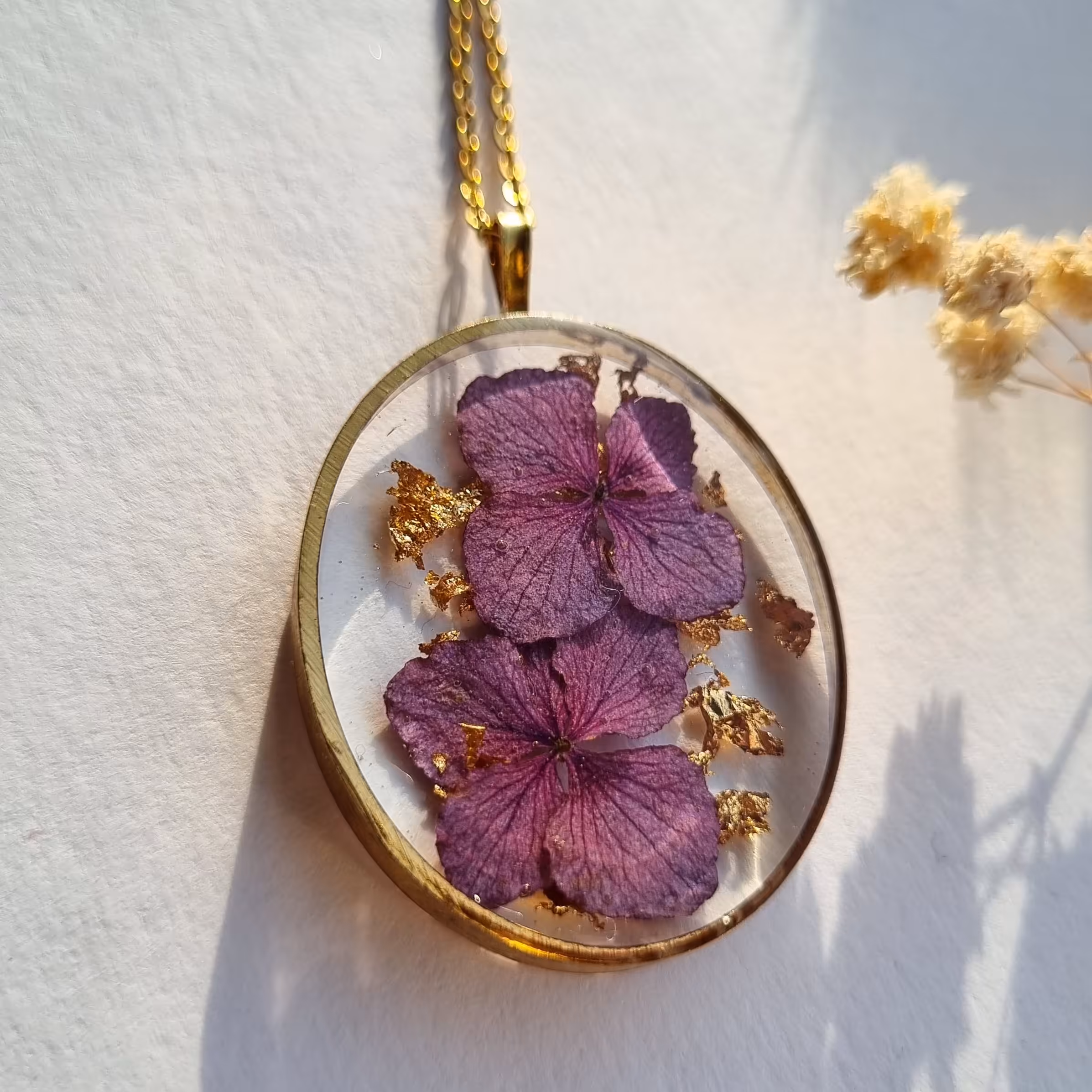 گردنبند رزینی ساخته شده با گل طبیعی فریم برنجی و زنجیر استیل رنگ ثابت