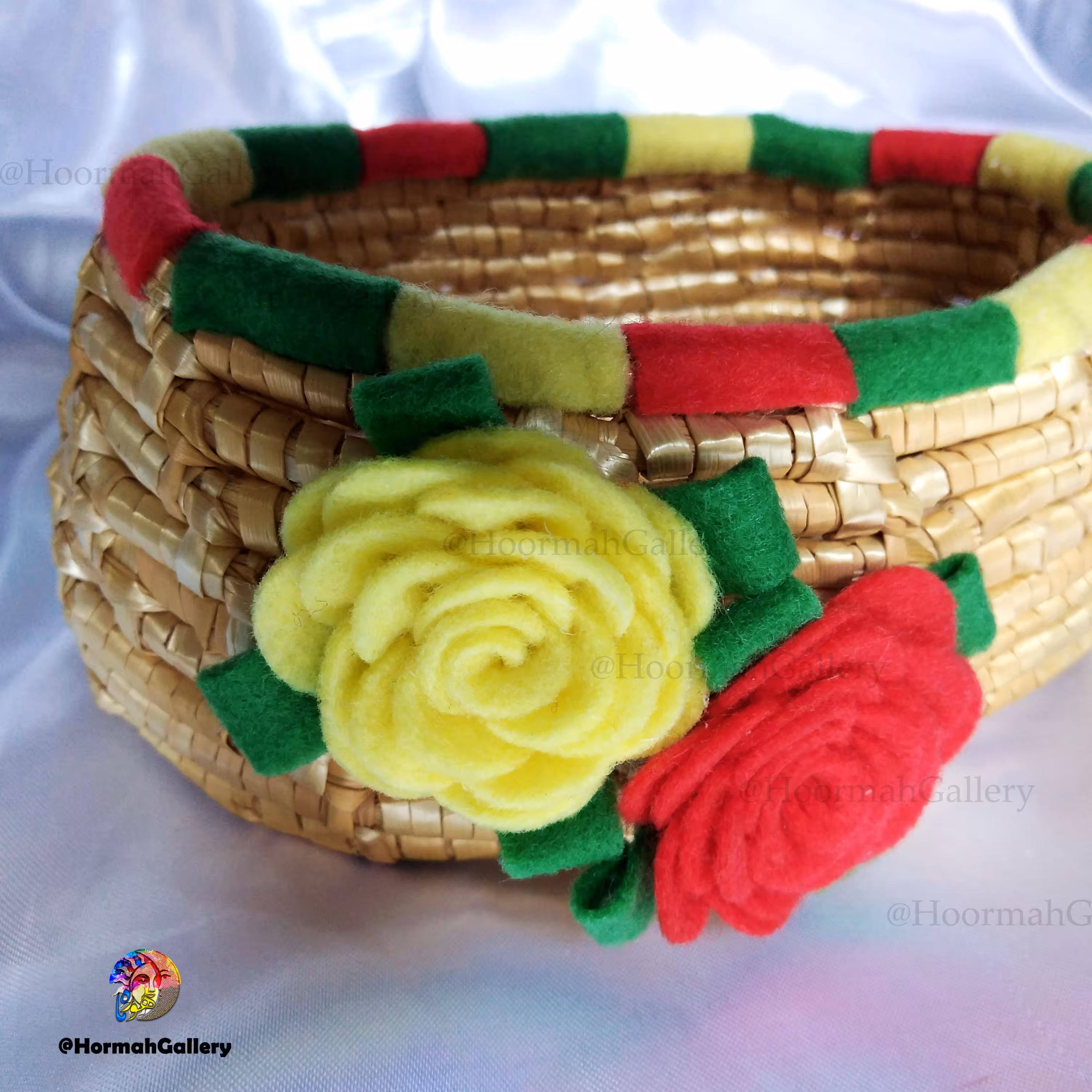یک عدد سبد حصیری تزئین شده با گل های نمدی رنگارنگ