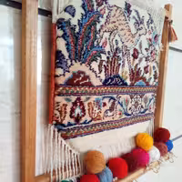 قطعه فرش دستباف  خشتی بیرجند نصب شده روی قاب چوبی دارای چنگک  برای آویزان کردن اشیا