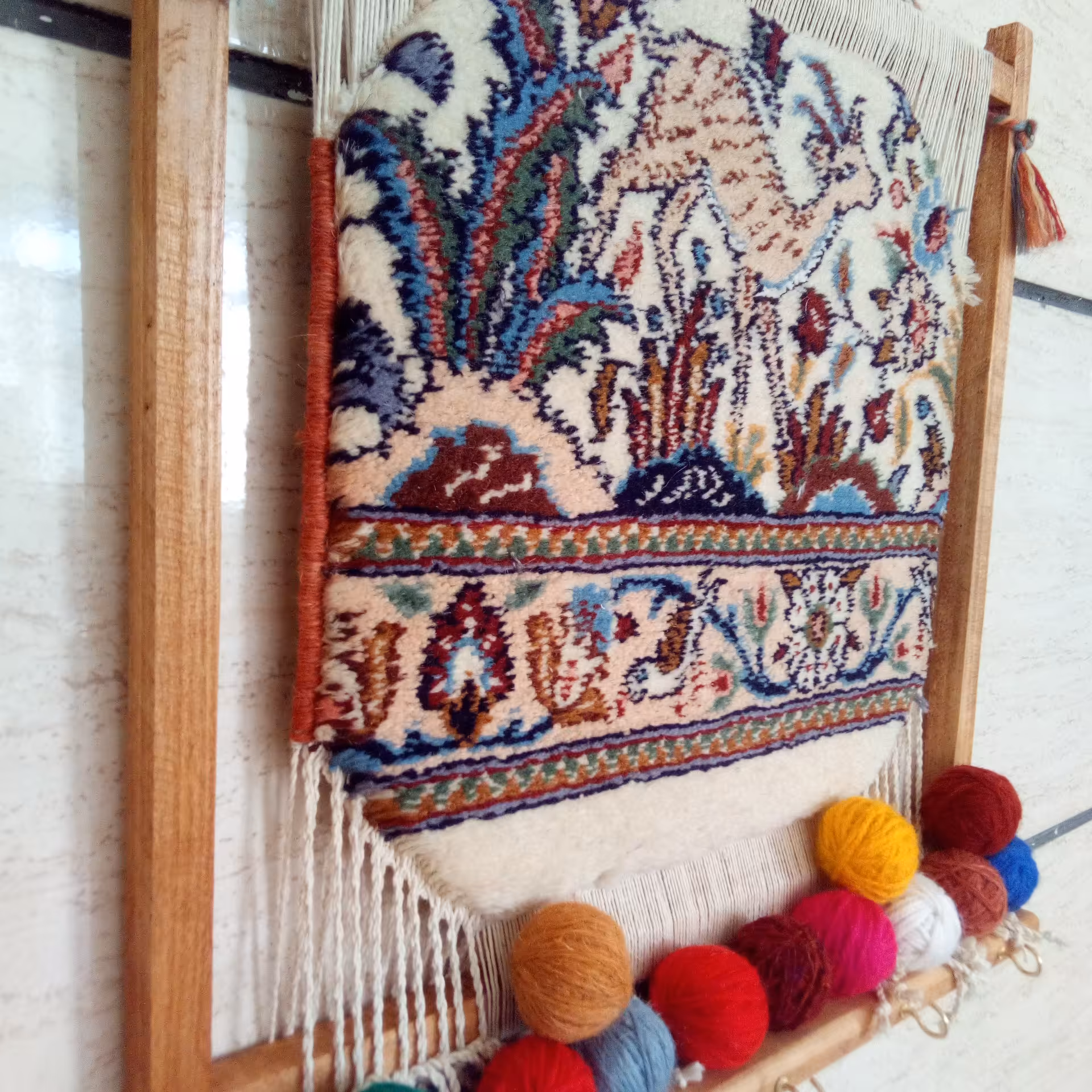 قطعه فرش دستباف  خشتی بیرجند نصب شده روی قاب چوبی دارای چنگک  برای آویزان کردن اشیا