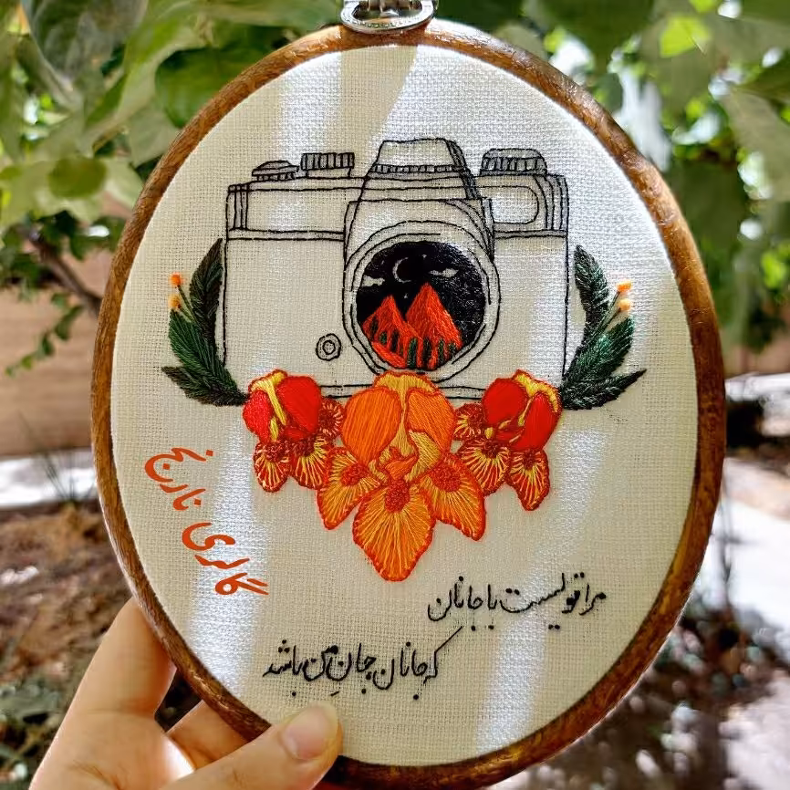 دیوارکوب گلدوزی شده  طرح دوربین  و گل به همراه بیت عاشقانه 