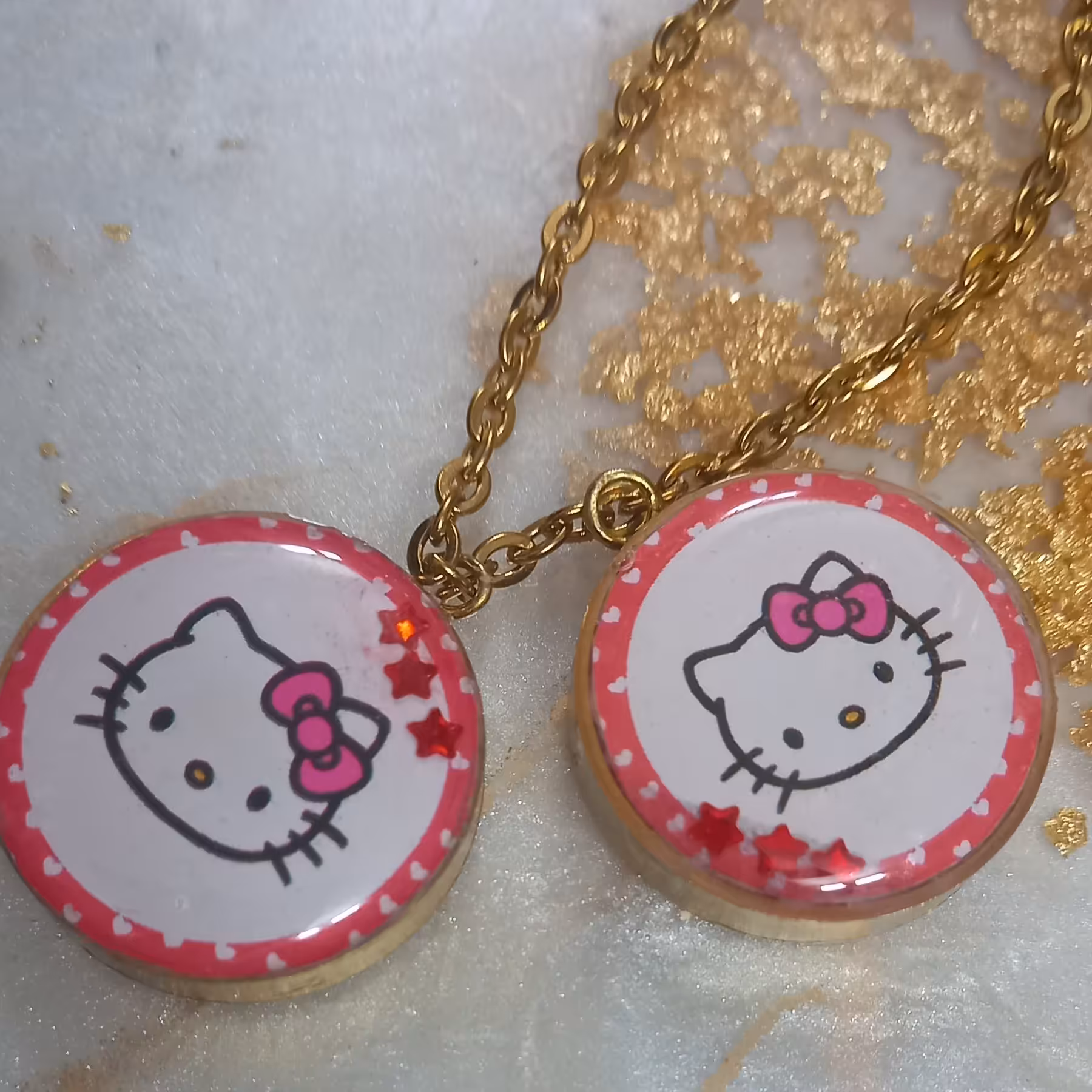 گردنبند،  جاسوئیچی طرح کیتی 
پشت کار صورتی اکلیلی .
 پلاک و زنجیر رنگ ثابت