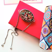 دستبند زنانه سنگ های متالیک دستبند زنانه رزینی دستساز مدل بیضی با قاب استیل و زنجیر استیل آسانسوری رنگ ثابت