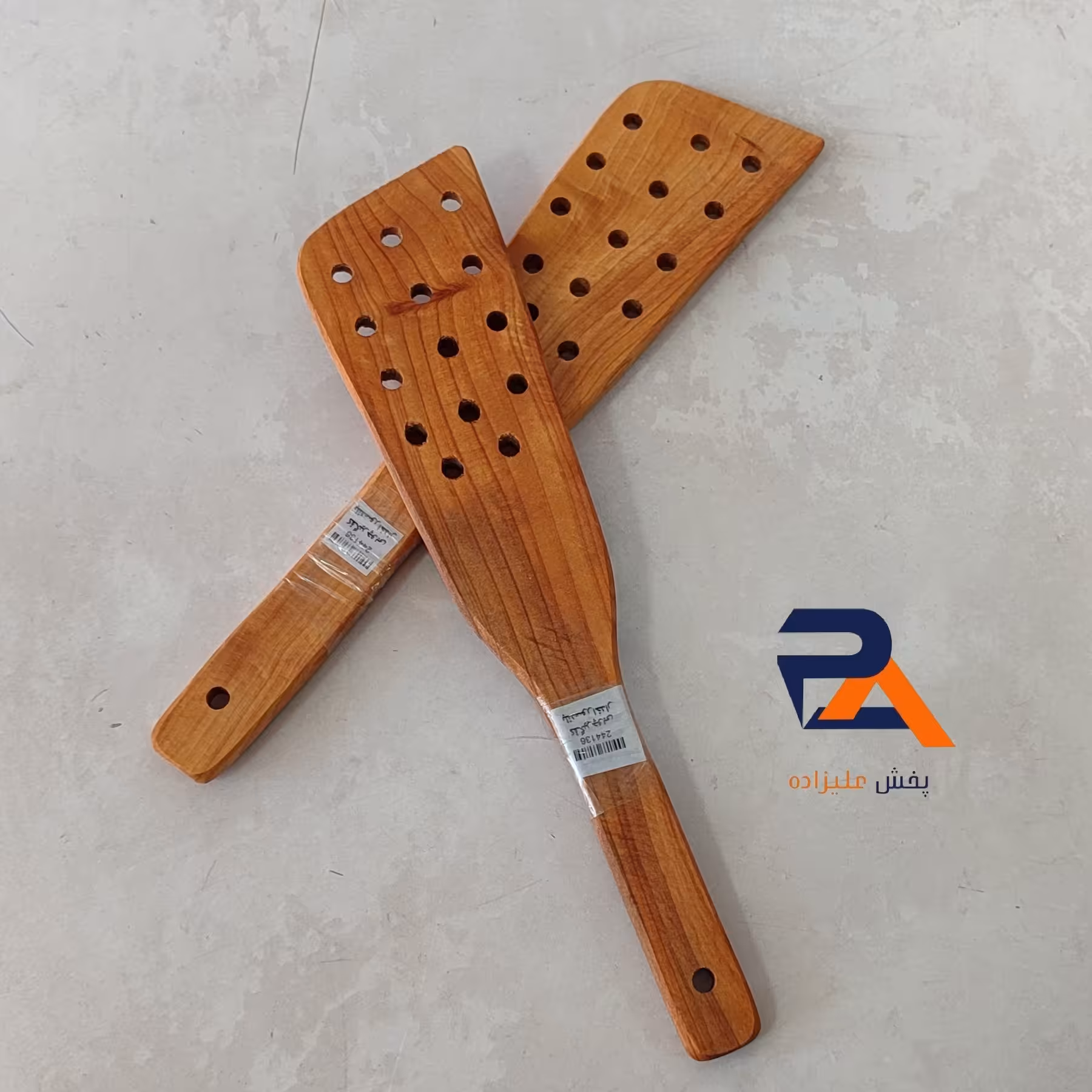 کفگیر برگردان سوراخدار سرکج چوبی دارای حلقه ی آویز  باکیفیت و مقاوم 