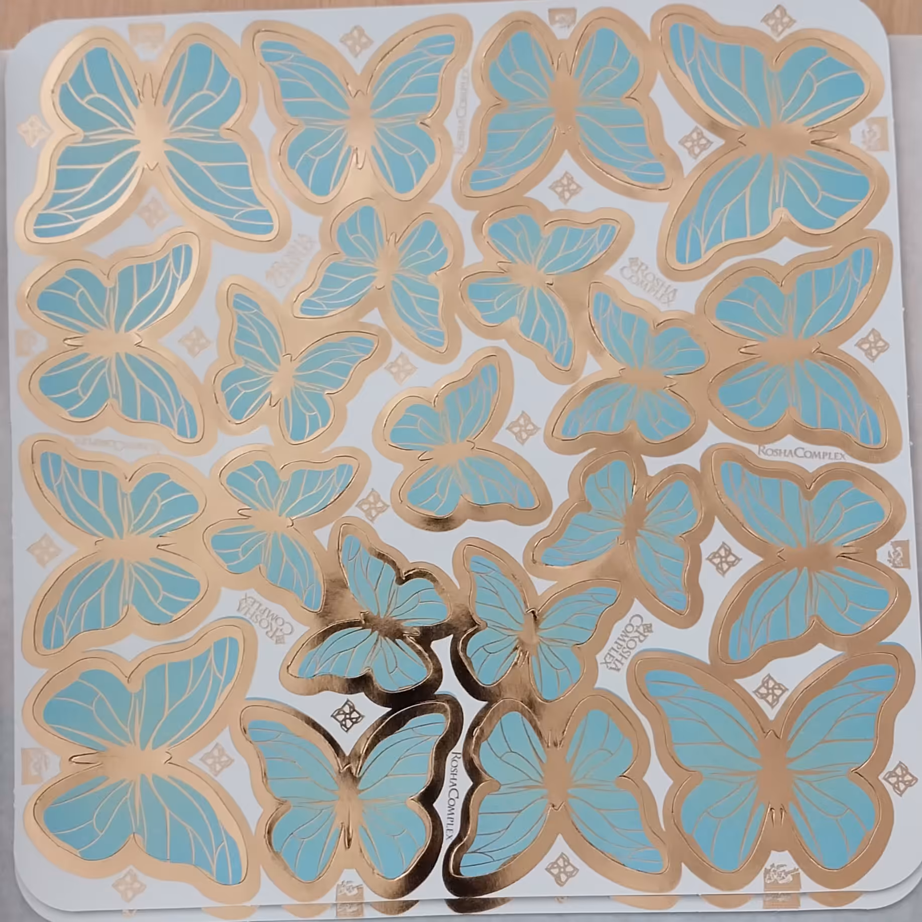 پروانه طلا کوب روی کیک برگه ای آبی