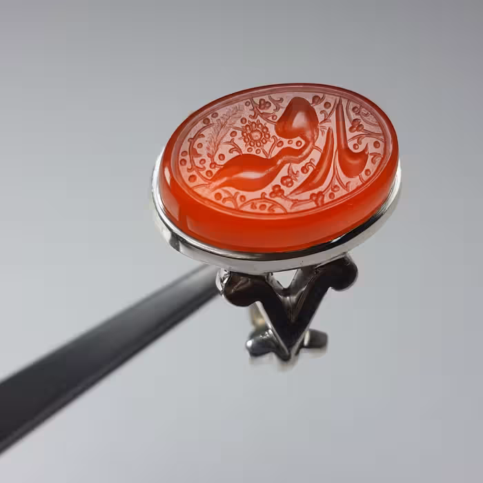 نگین عقیق سرخ 
رکاب دست ساز مدل صفوی 
حرز امام جواد علیه السلام 
تربت امام حسین علیه السلام زیر نگین 
ابعاد نگین 18 در 1