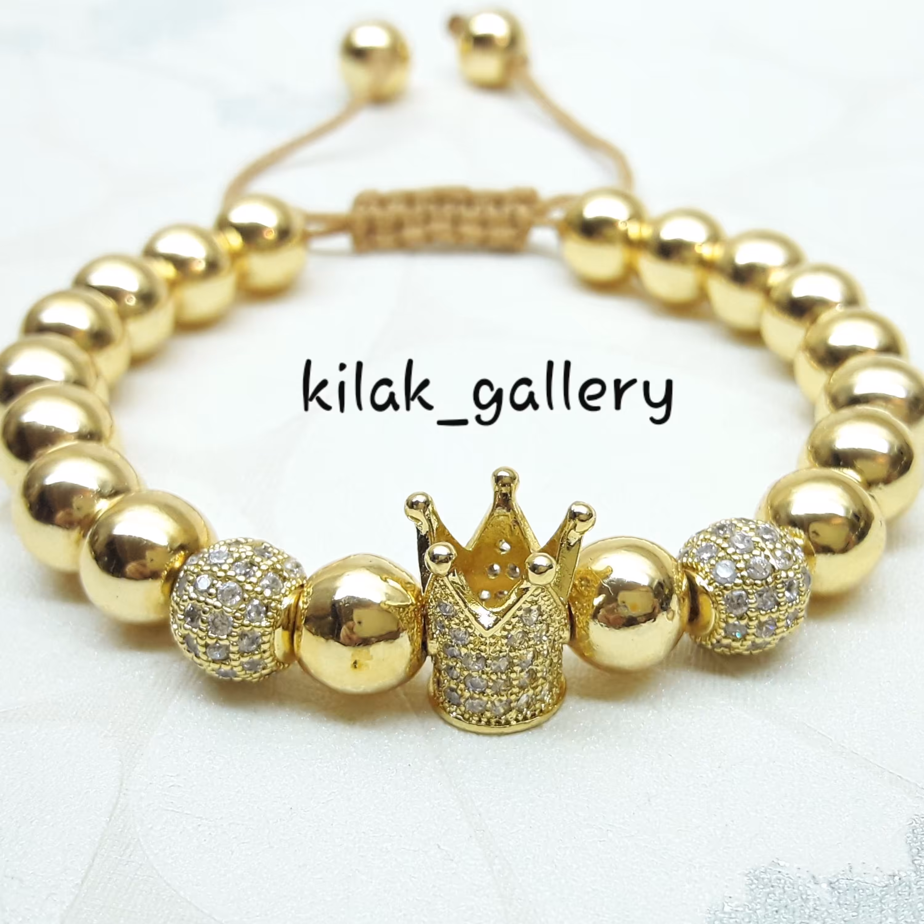 دستبند سنگ حدید طلایی با یک عدد تاج و دو عددگوی سوارسکی طلایی مدل کویین 