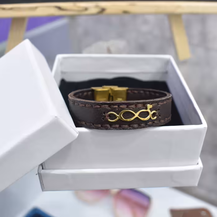 دستبند چرم طبیعی  دست دوز و نقره آبکاری طلا  طرح بینهایت