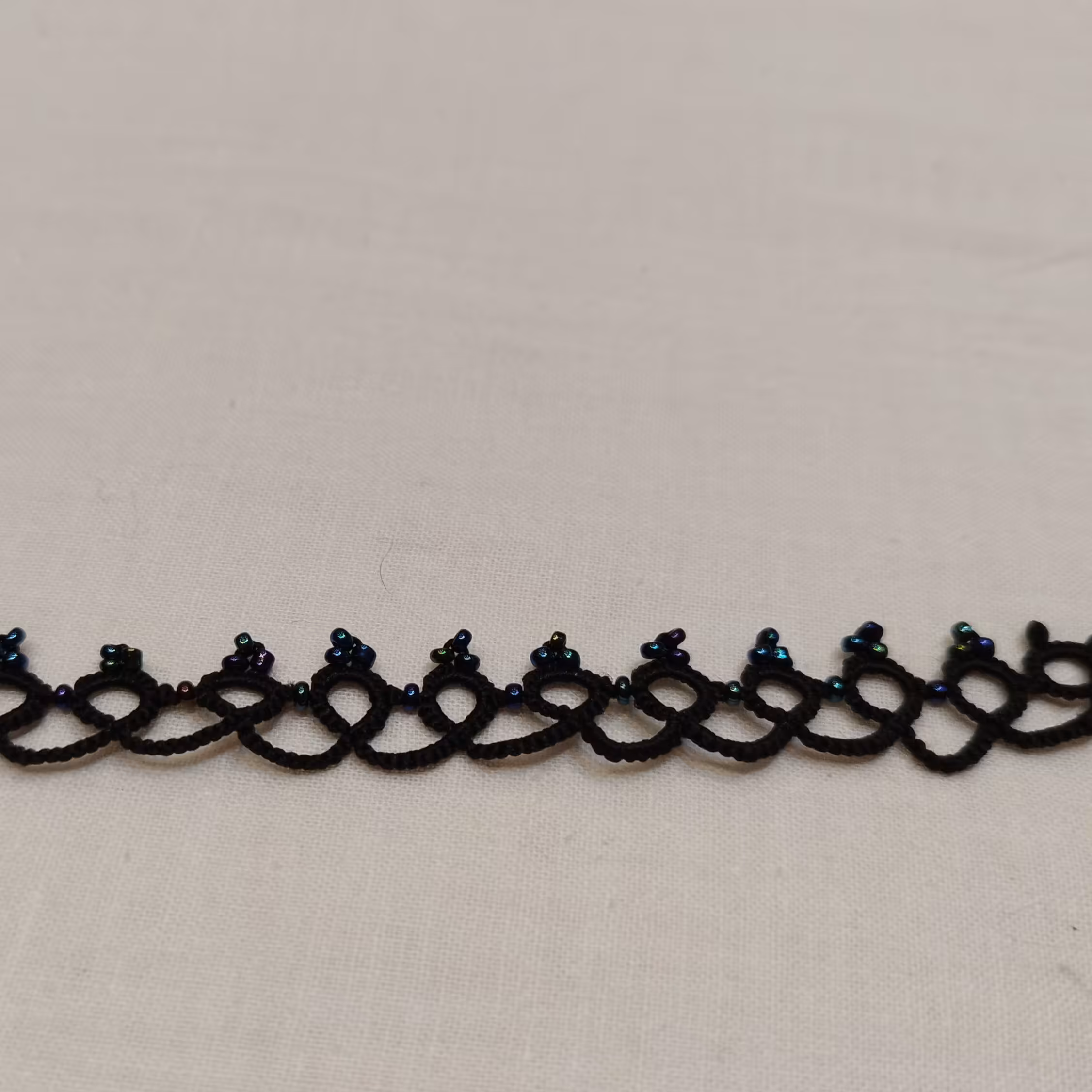 دستبند گیپور بافی با نخ مرسریزه دستباف. همراه با منجوق رنگ مشکی 