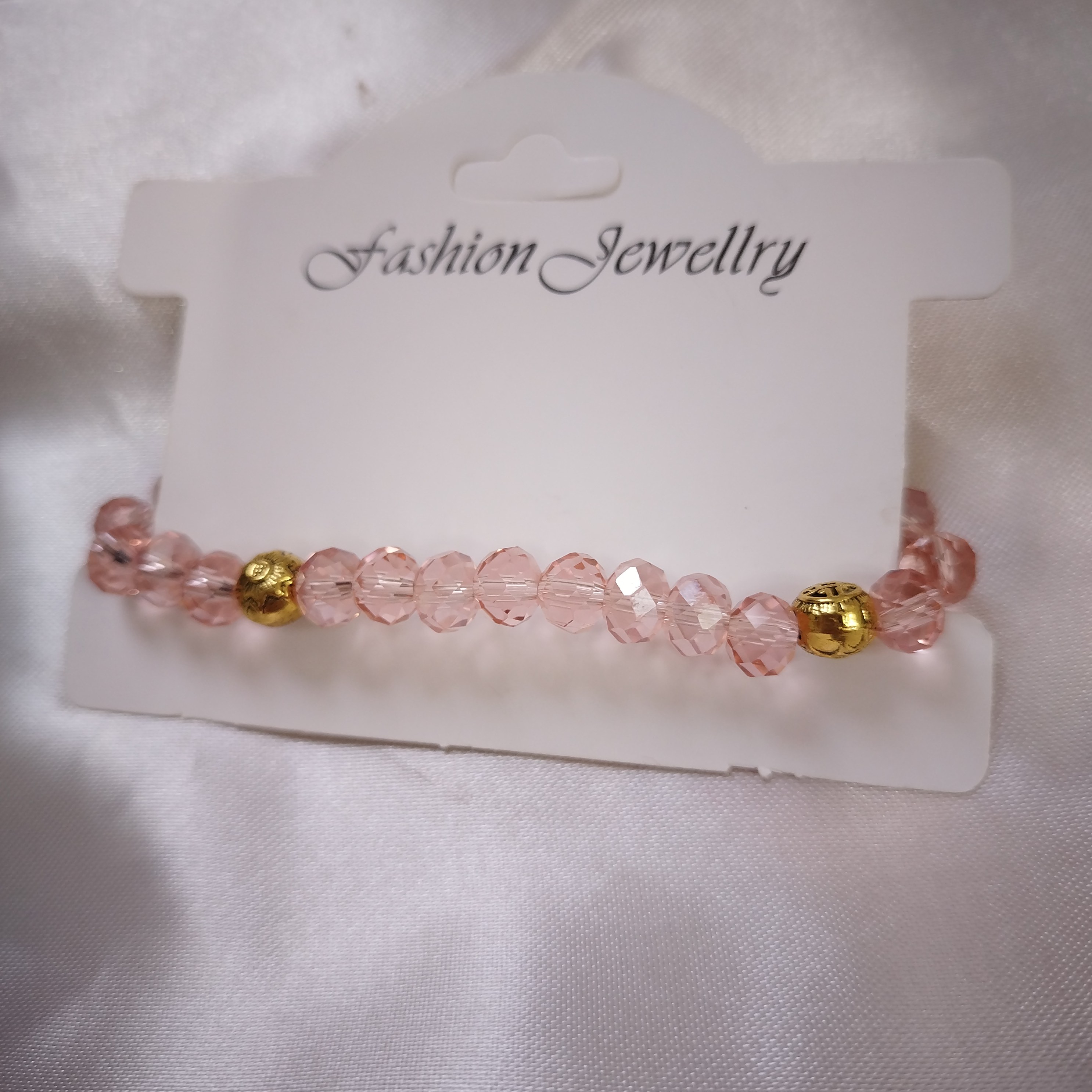 دستبند رنگ صورتی ملایم حدید طلایی که هردو طرف شکل داره