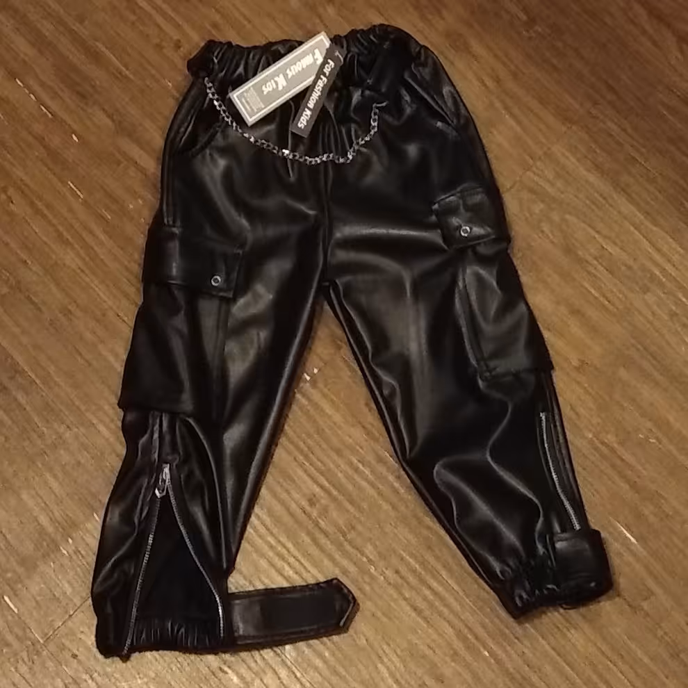 شلوار چرم کش وارداتی زنجیر دار اسلش پایین زیپ و چسب دار مناسب برای 4 سال