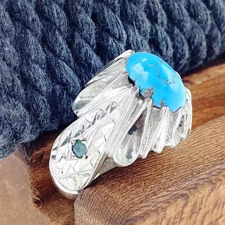 نگین فیروزه نیشابوری درجه یک اصلی با رکاب نقره دستساز با مخراج دو عدد زمرد معدنی