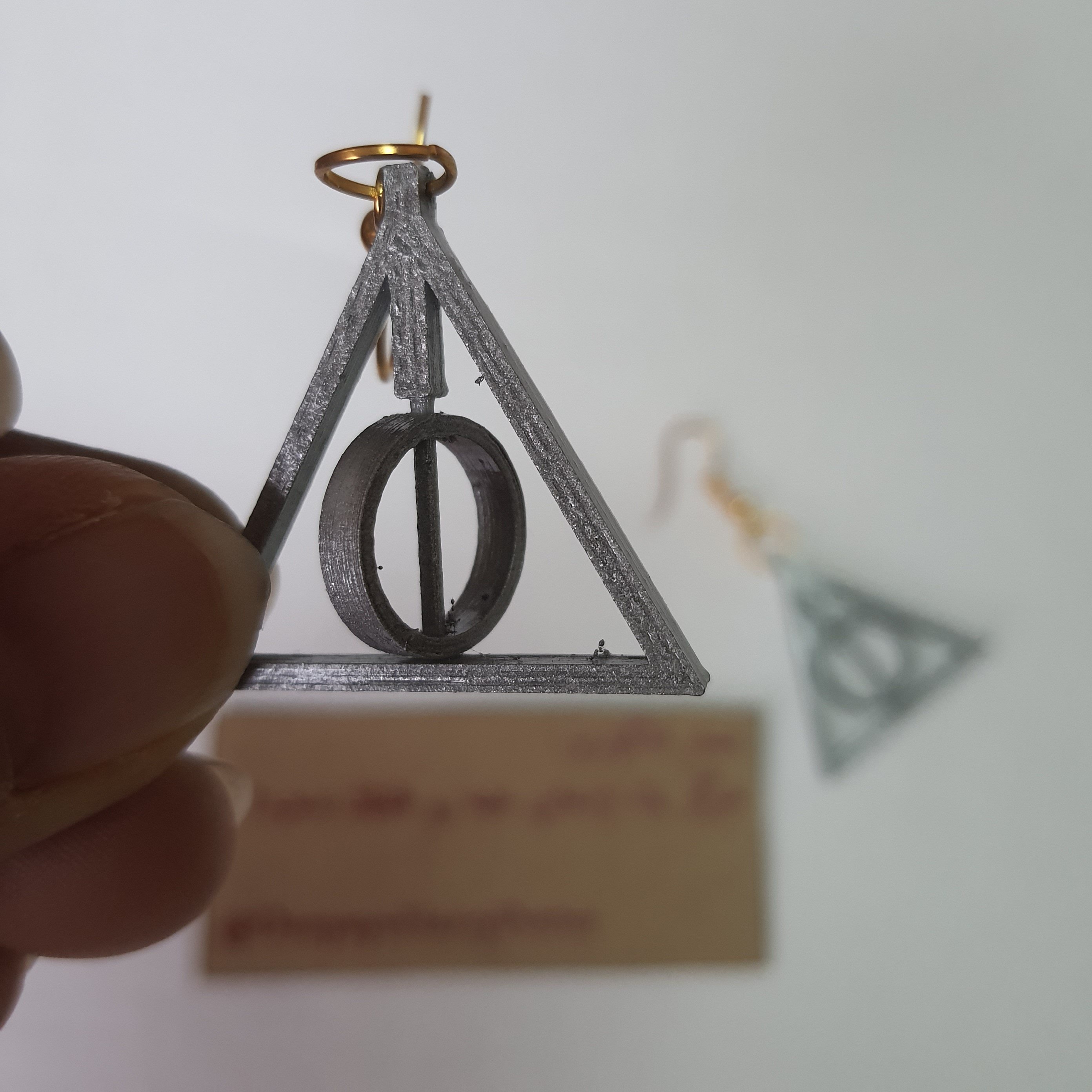 گوشواره طرح یادگاران مرگ از مجموعه هری پاتر نقره ای چرخان جنس pvc