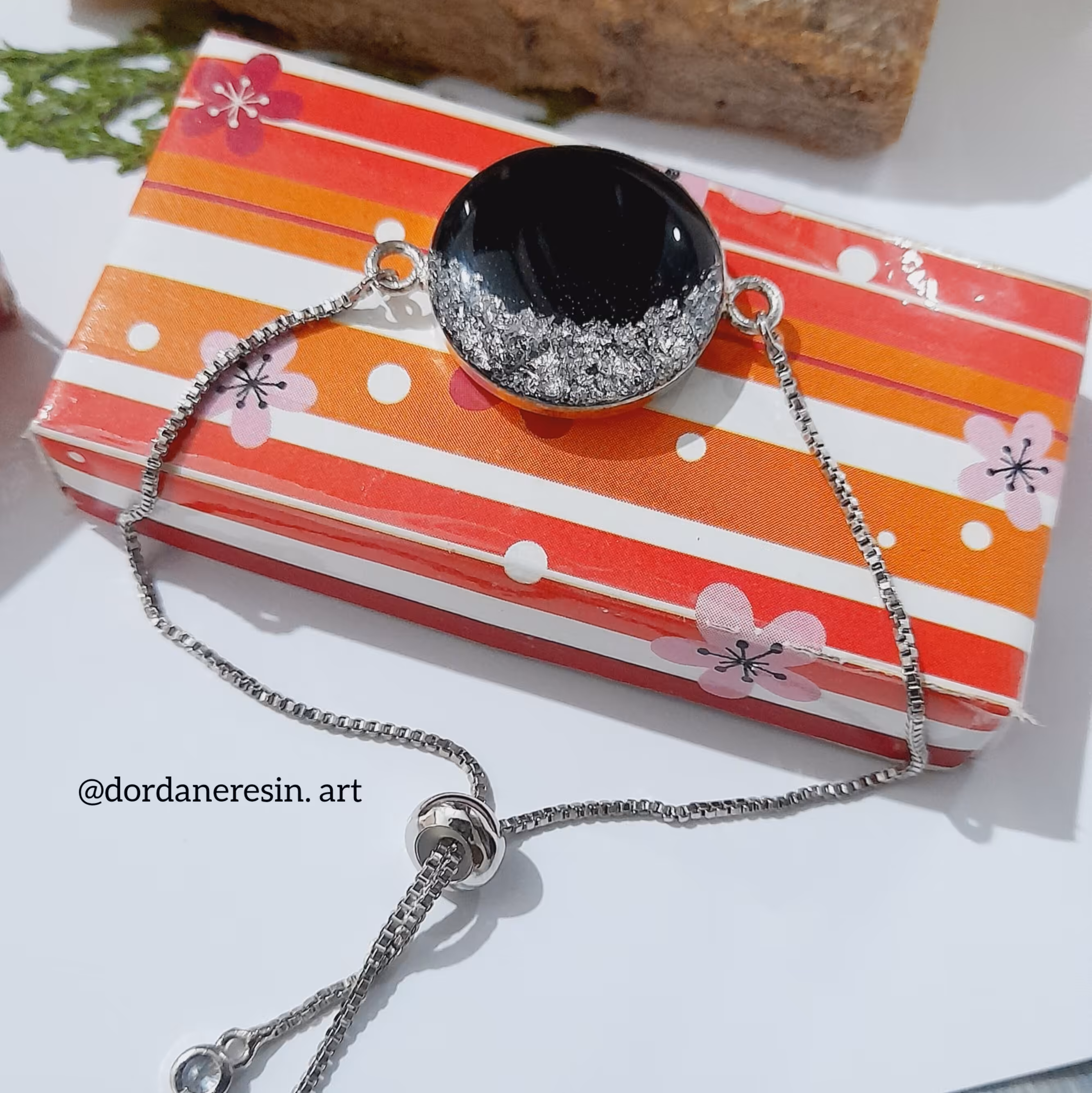 دستبتد رزینی  مشکی ونقره ای  با بند اسانسوری قابل تنظیم. 