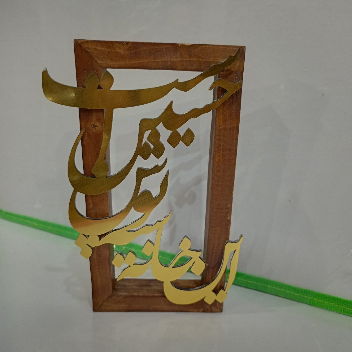 تندیس طلایی با قاب چوبی طرح این خانه سیه پوش حسین است

