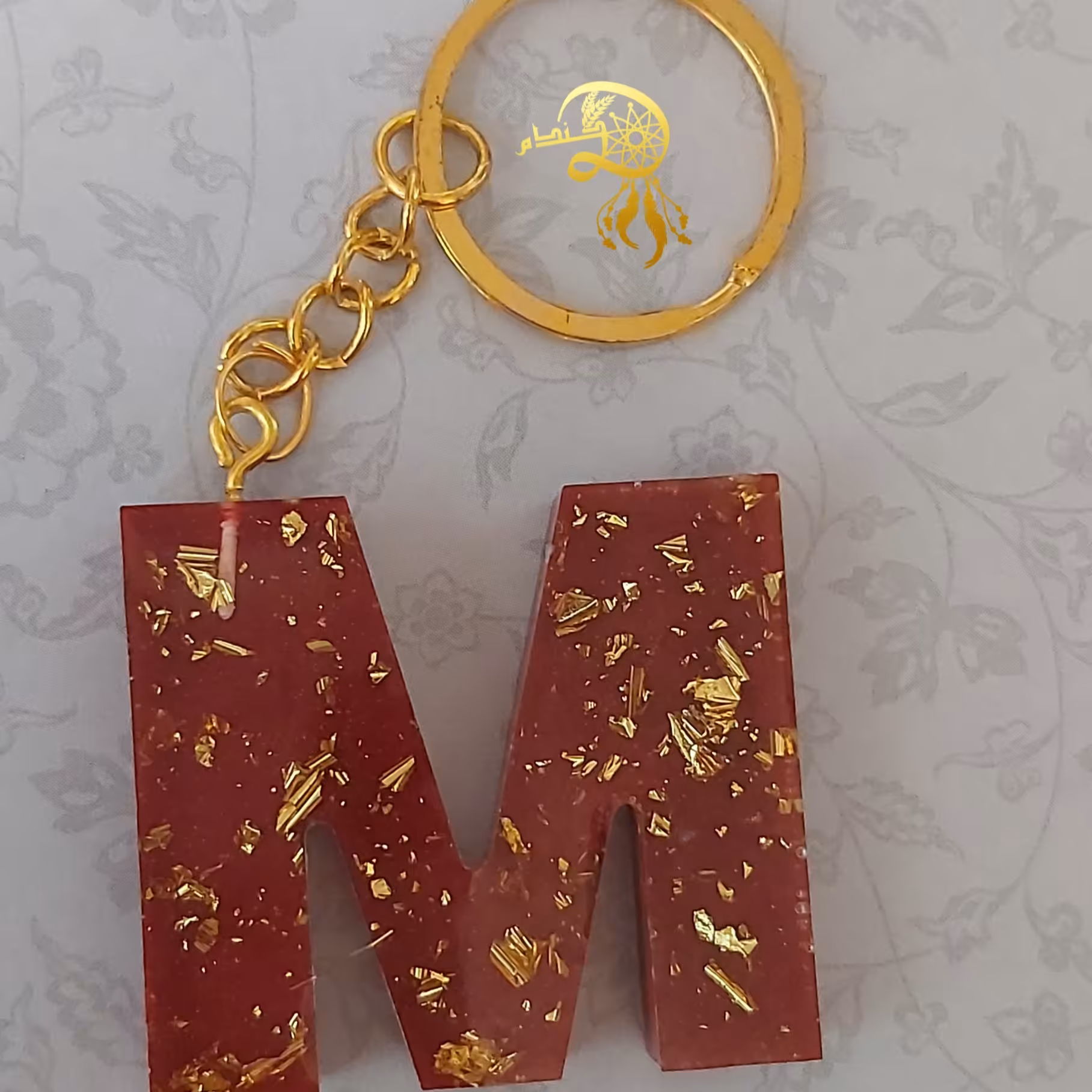 جاکلیدی رزینی حرف Mرنگ زرشکی باورق طلا یک عدد