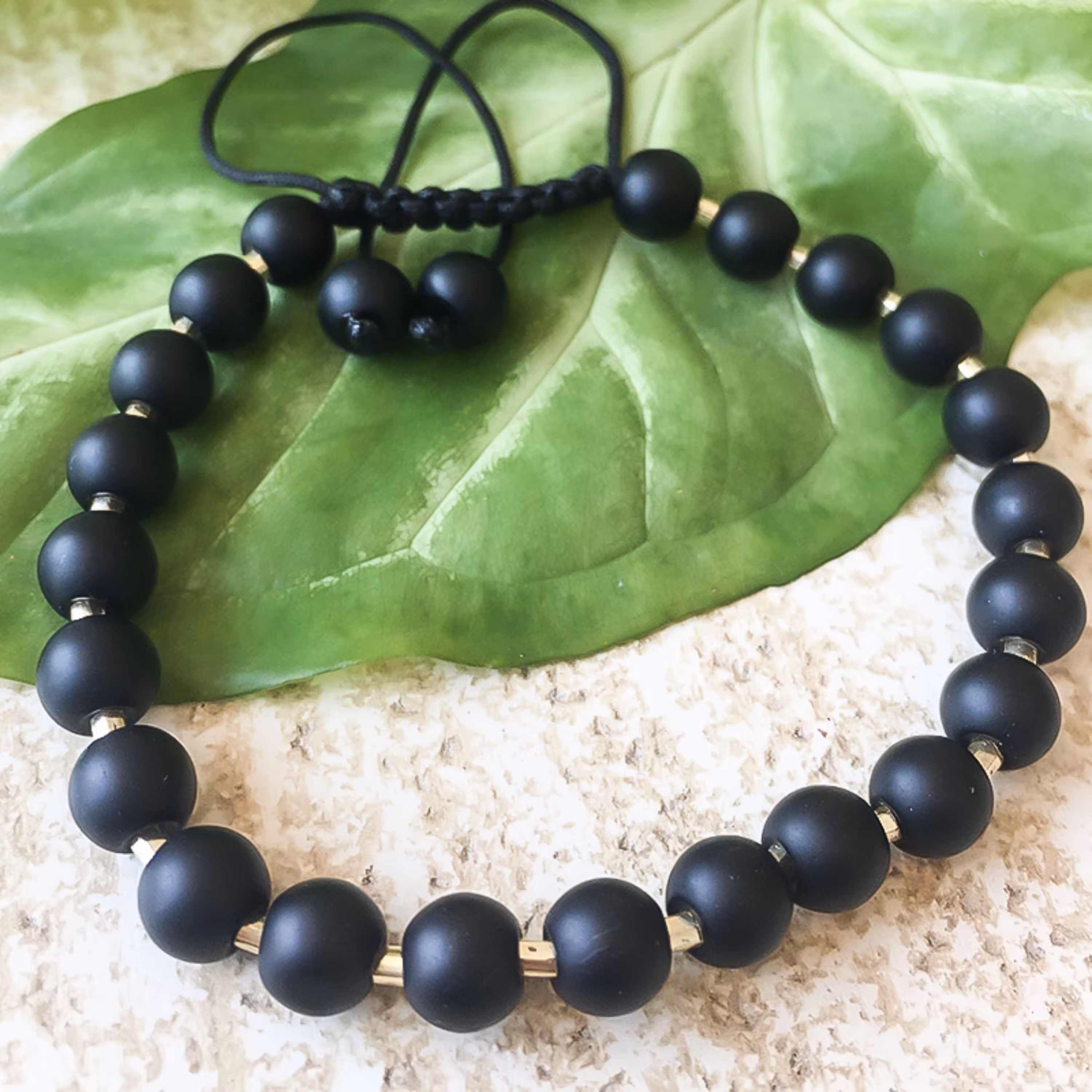 دستبند مدل تندر سنگ های اونیکس مات مشکی و منجوق طلایی زنانه و مردانه